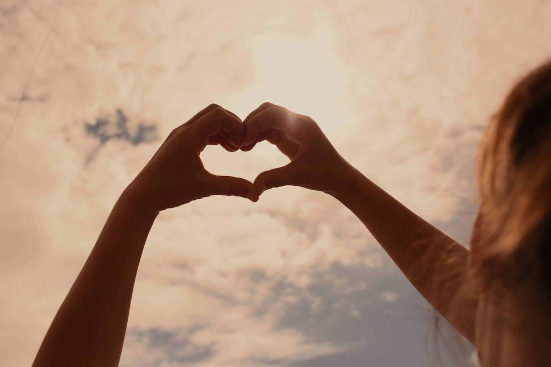 A girl forming a heart sign.
