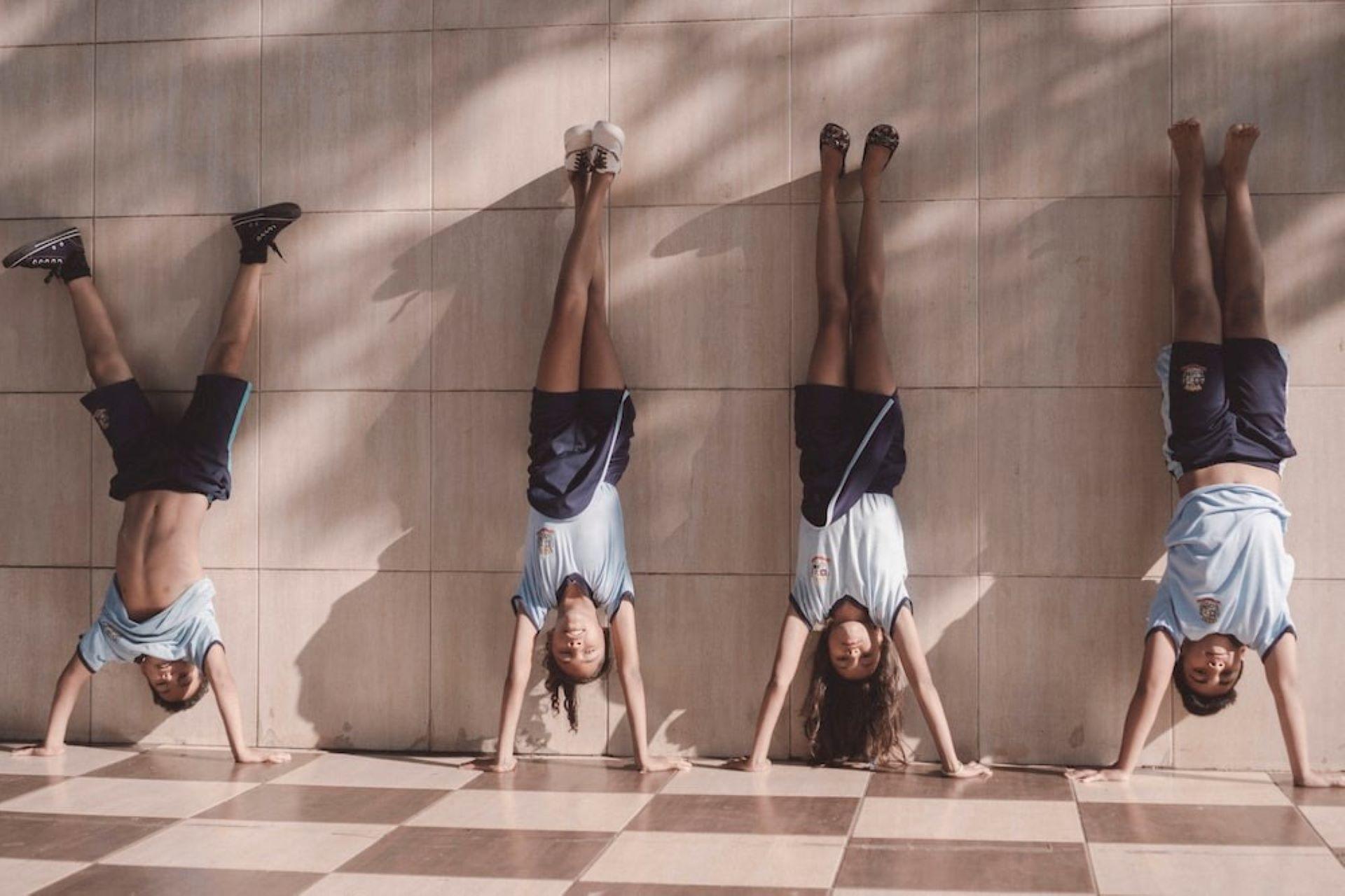 A group of gymnasts stretching on a wall.