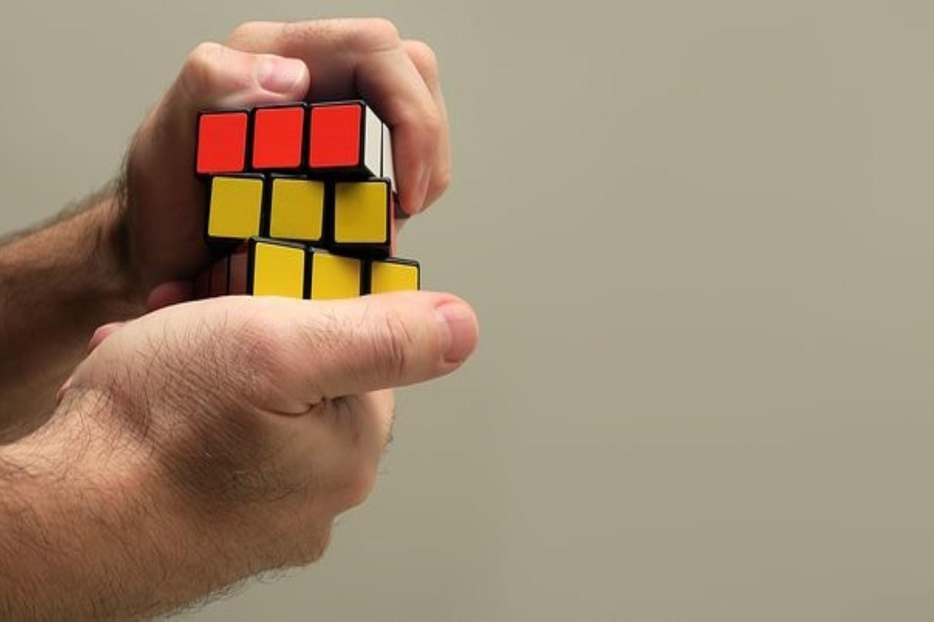 A man holding a solved Rubik's cube.