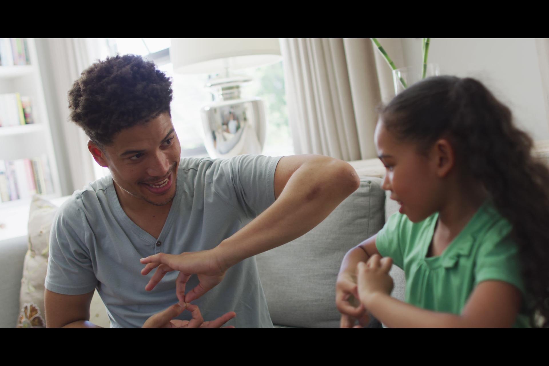 A person teaching sign language to a kid