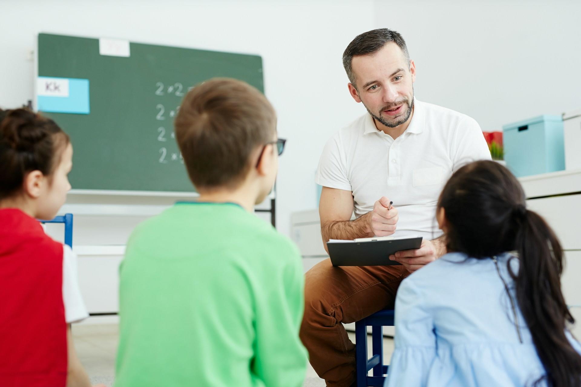 A male teacher in front of three teacher.