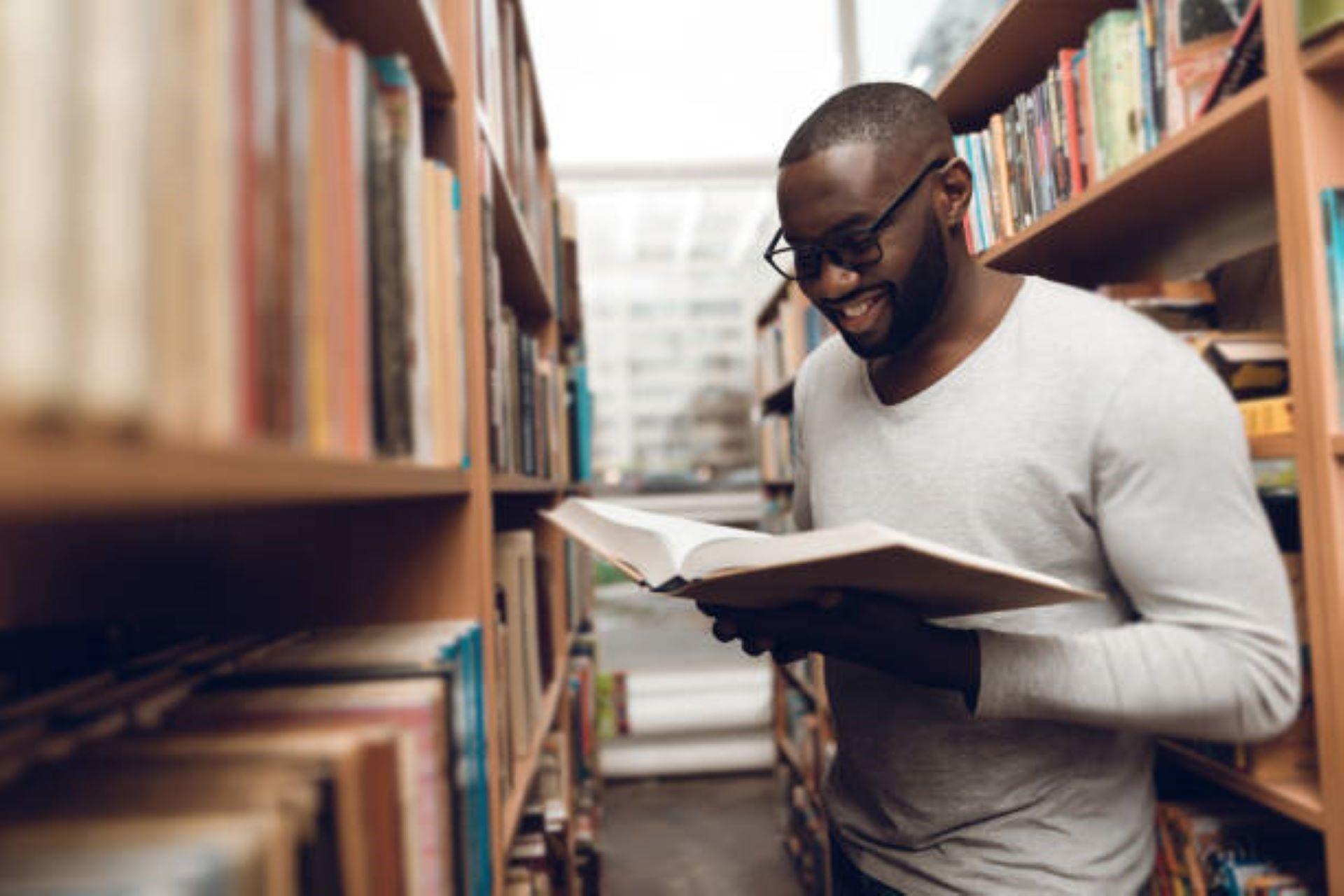 African Man reading a book in the library