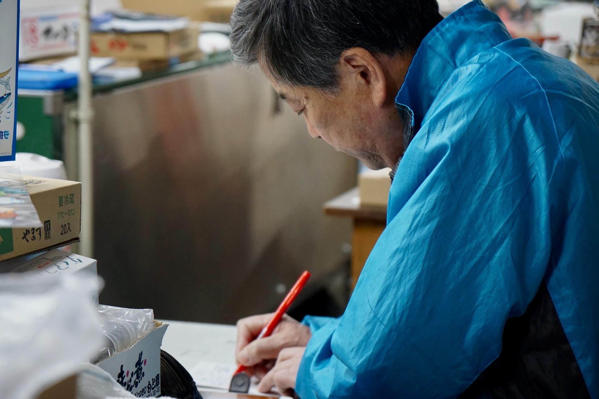 A man writing in a stock room