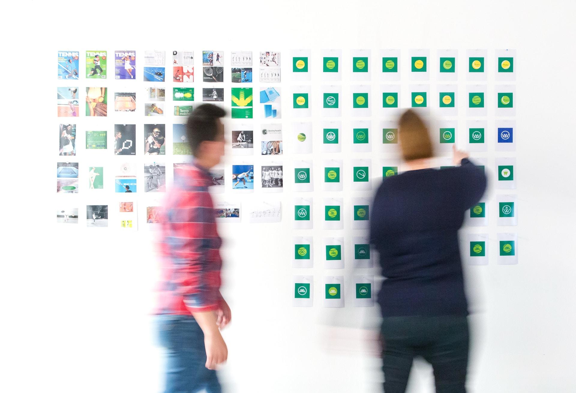 A wall of different story and graphic design elements with people adjusting them.