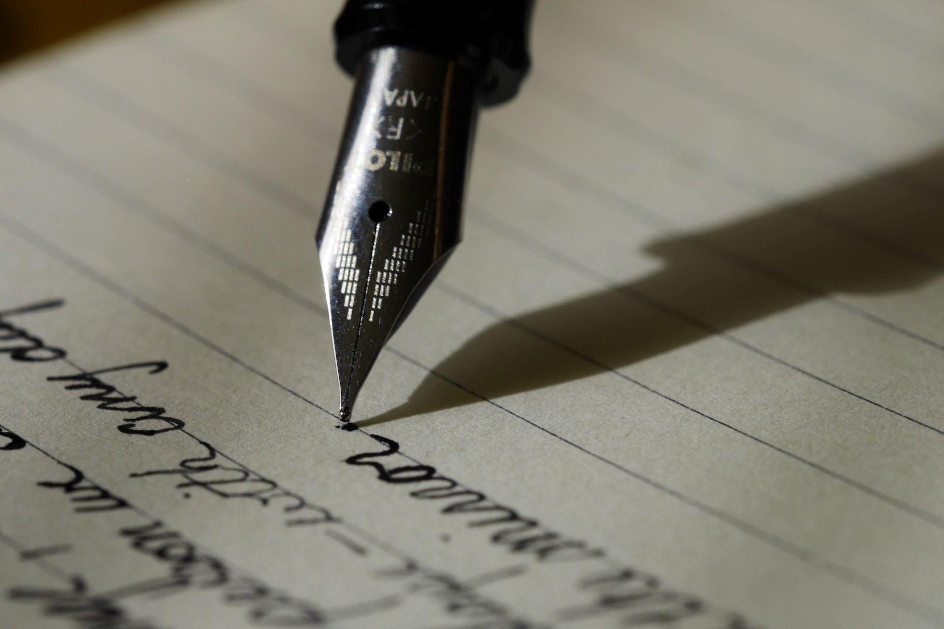 A fountain pen writing on note paper.