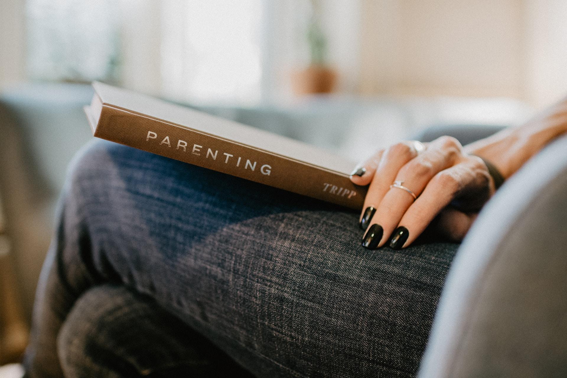 Parenting book on mother's lap.