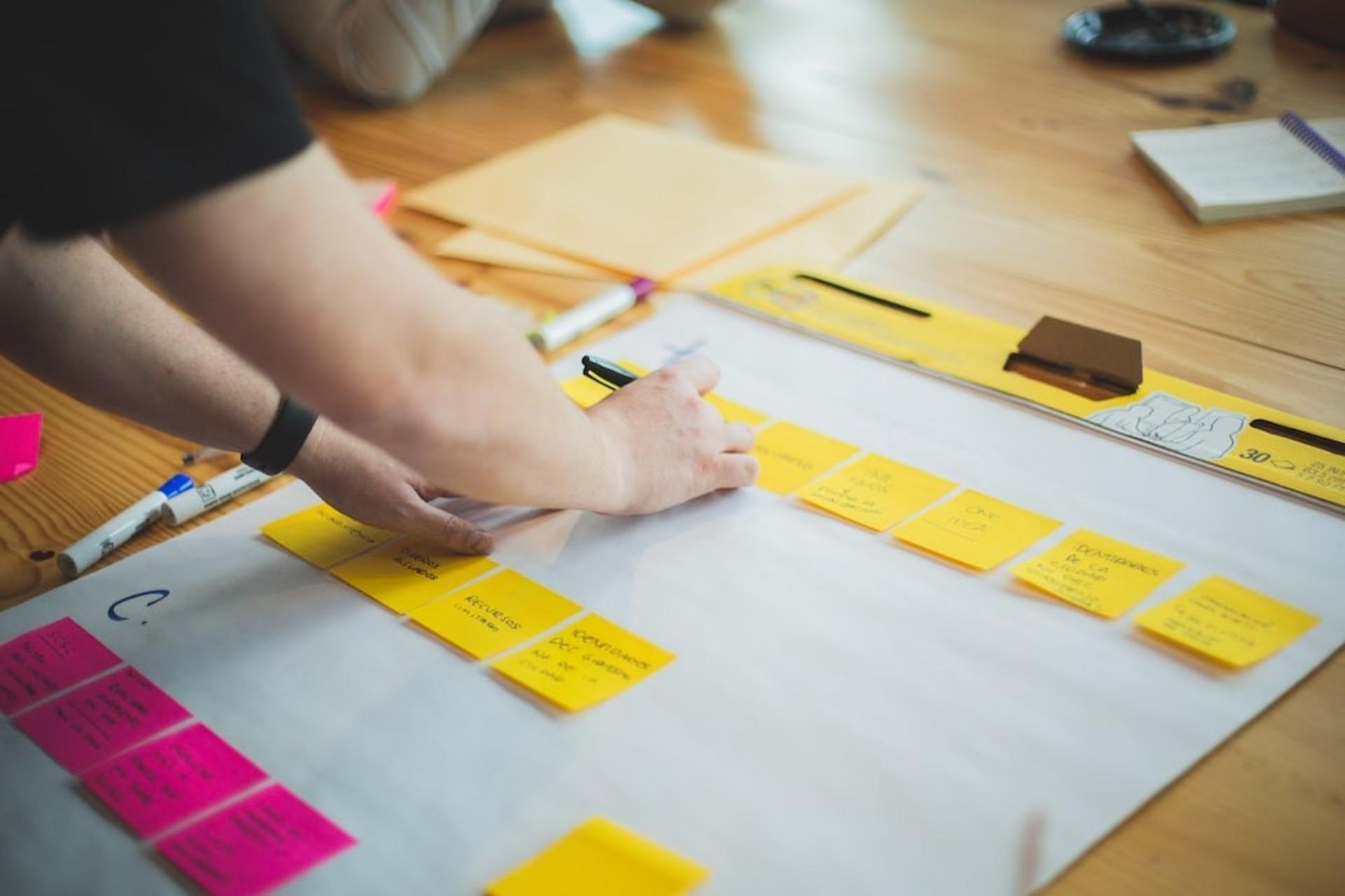 A person mapping the project details using project management techniques.