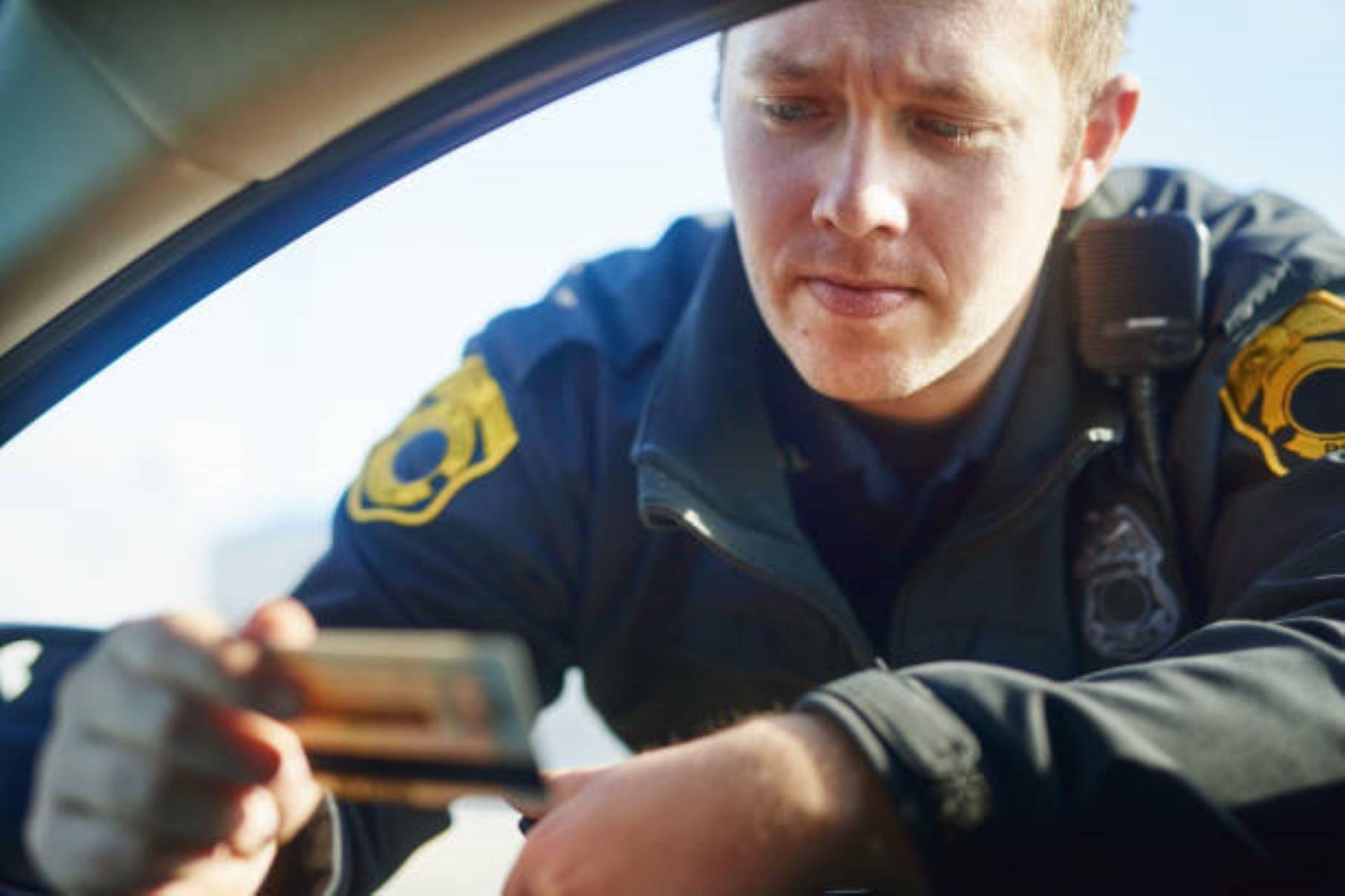 Traffic officer checking a driving license at a roadblock (Source: istockphoto