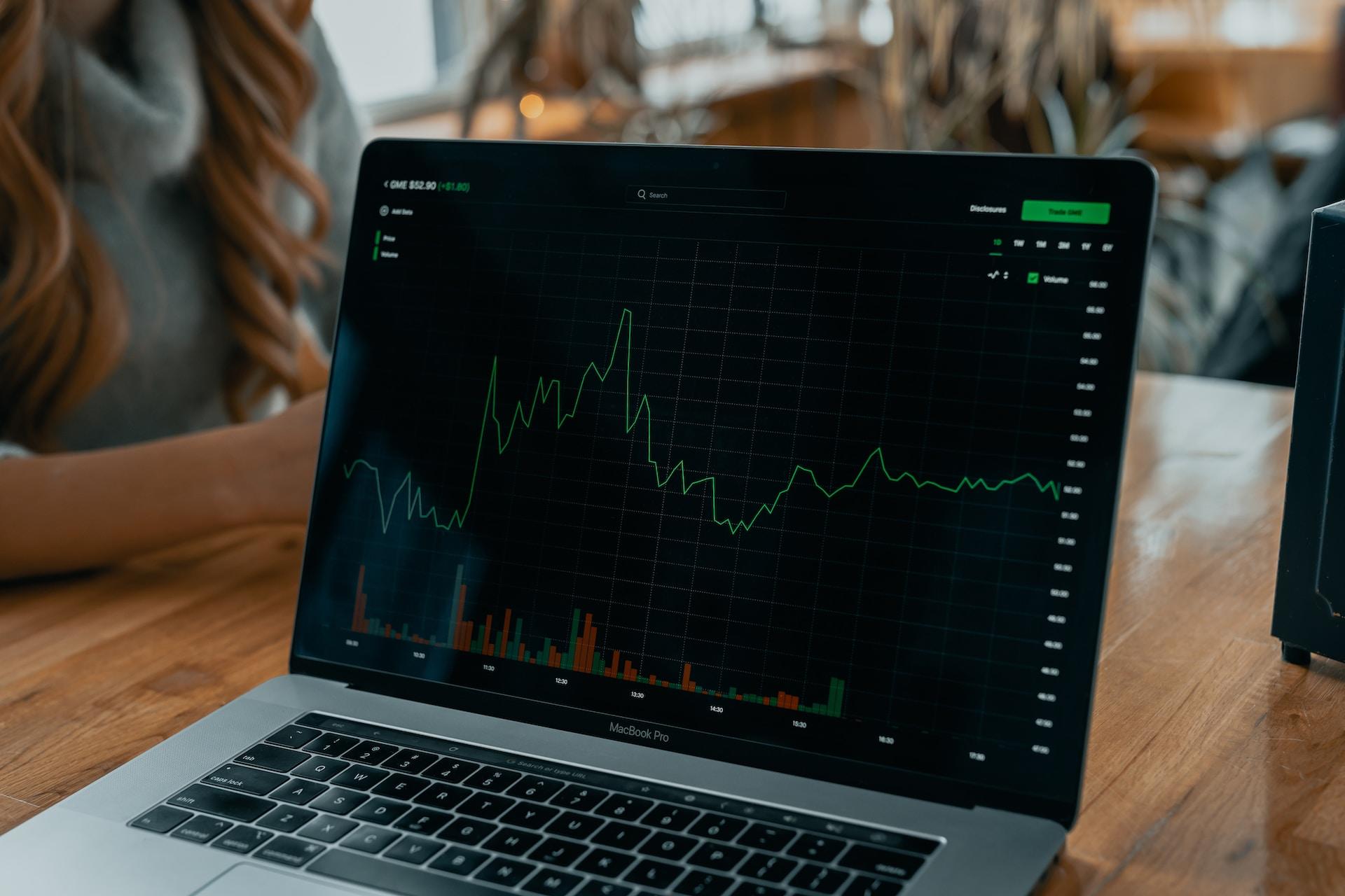 A laptop screen with a crypto or stock trading graph.