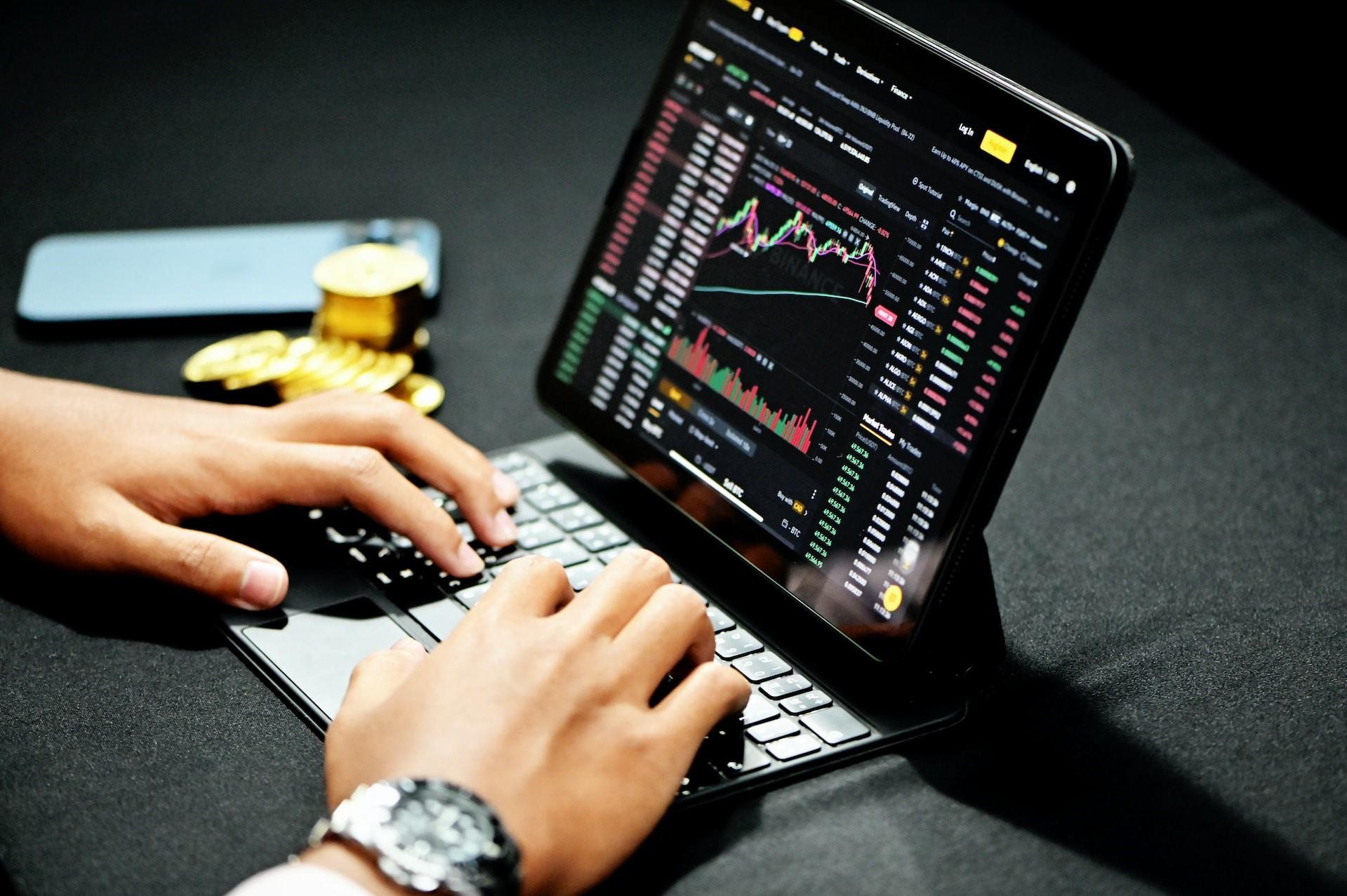 A person trading cryptocurrency on a laptop.
