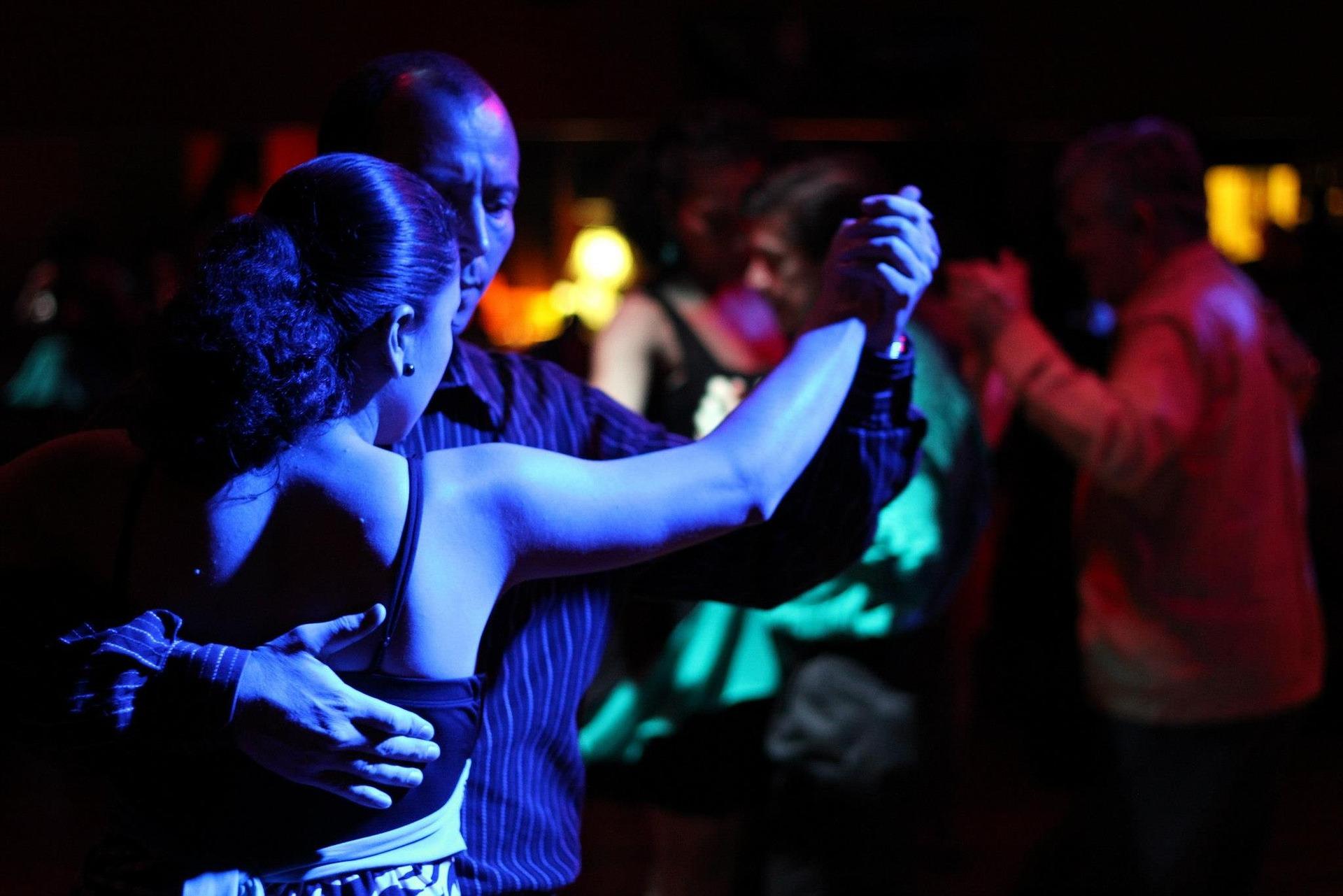 Dancing couple in a club lit by blue lights.