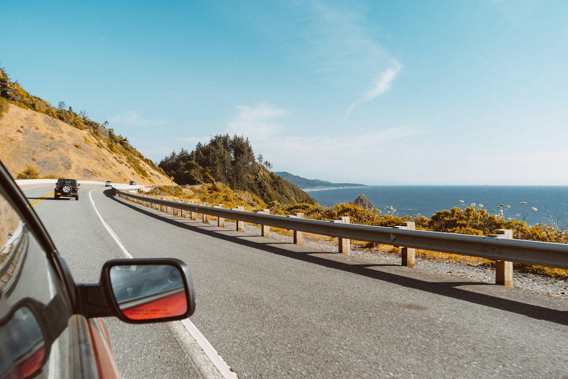 A car driving along a oceanside highway.