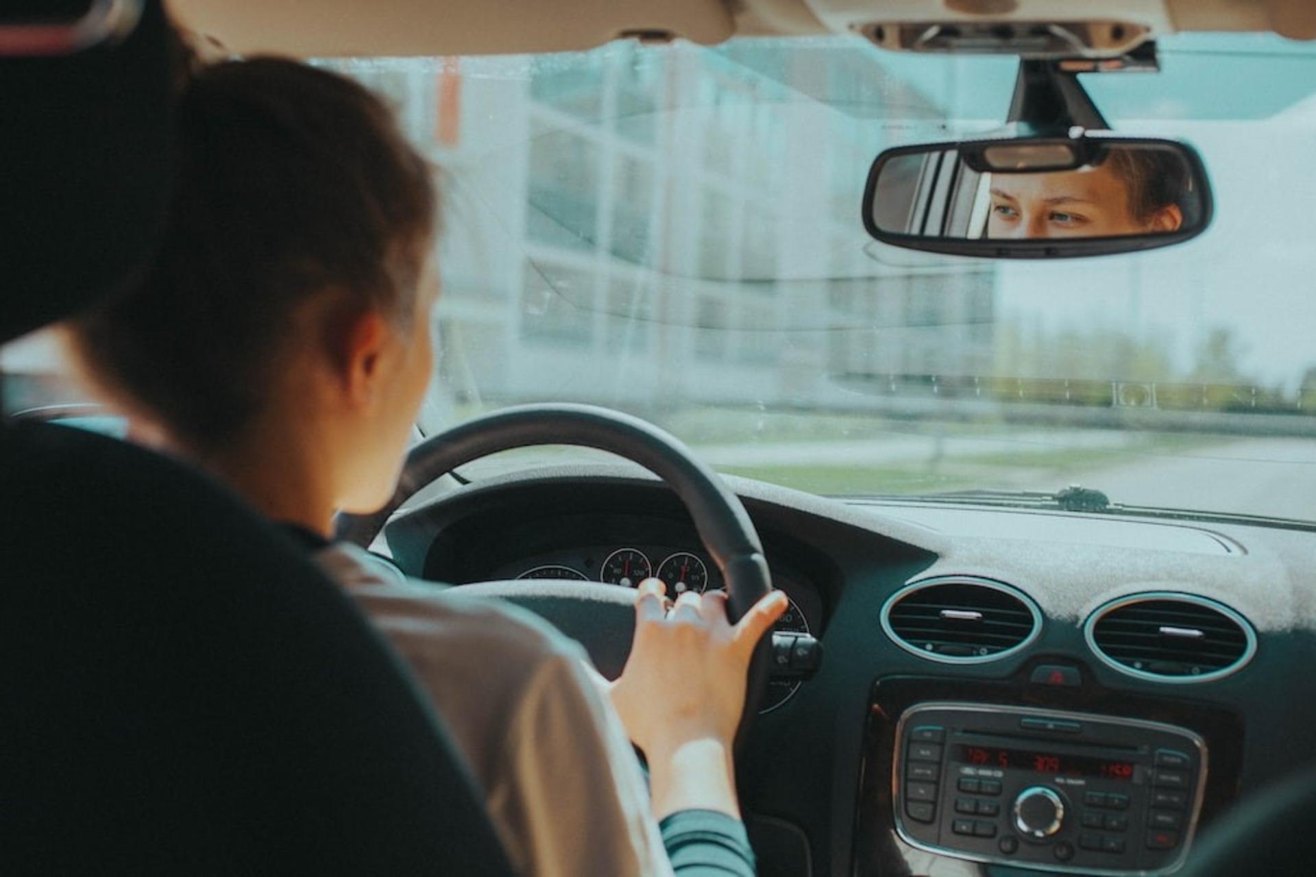 A woman practicing driving on a city street