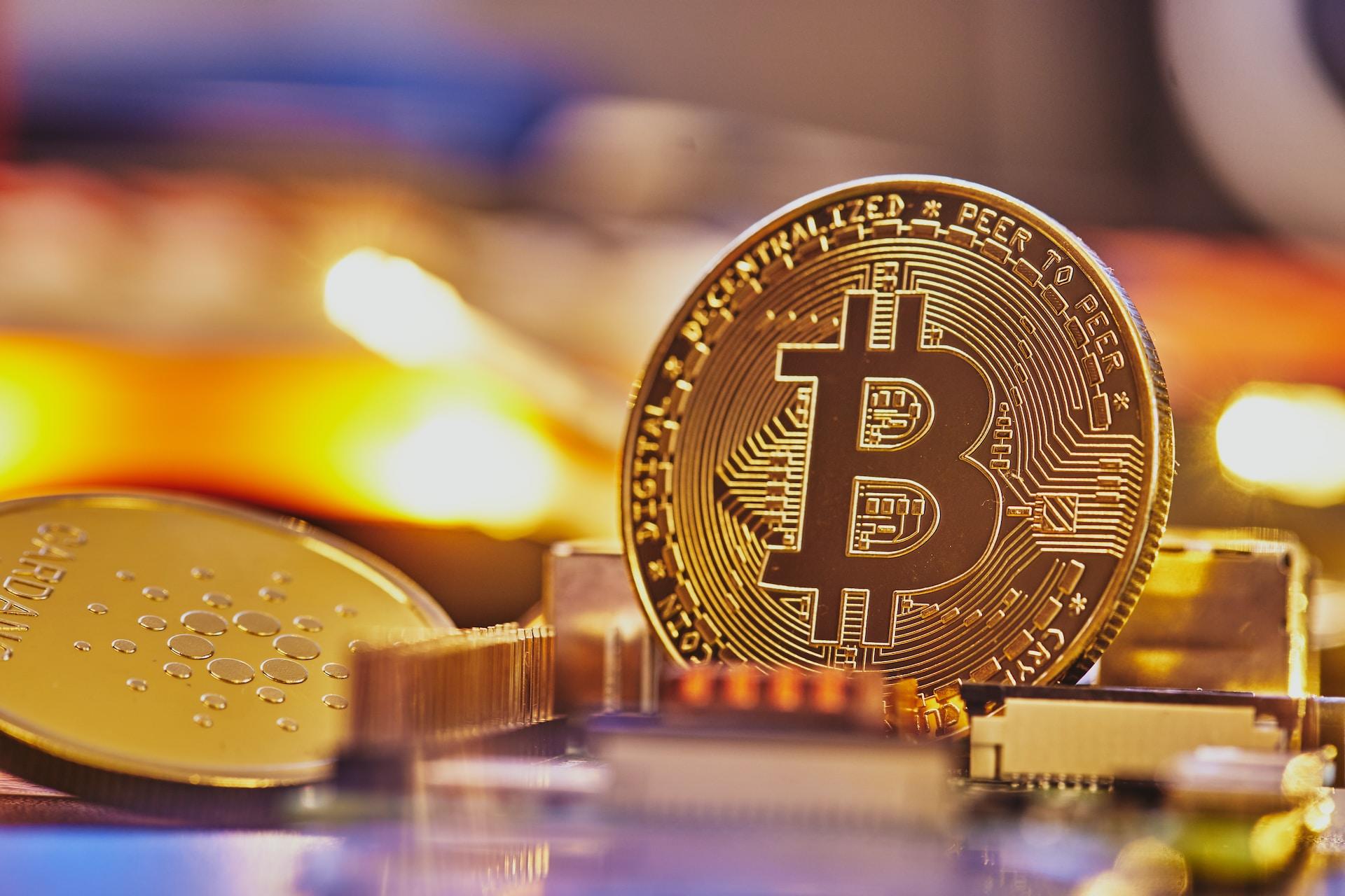 A physical Bitcoin next to other physical cryptocurrencies.