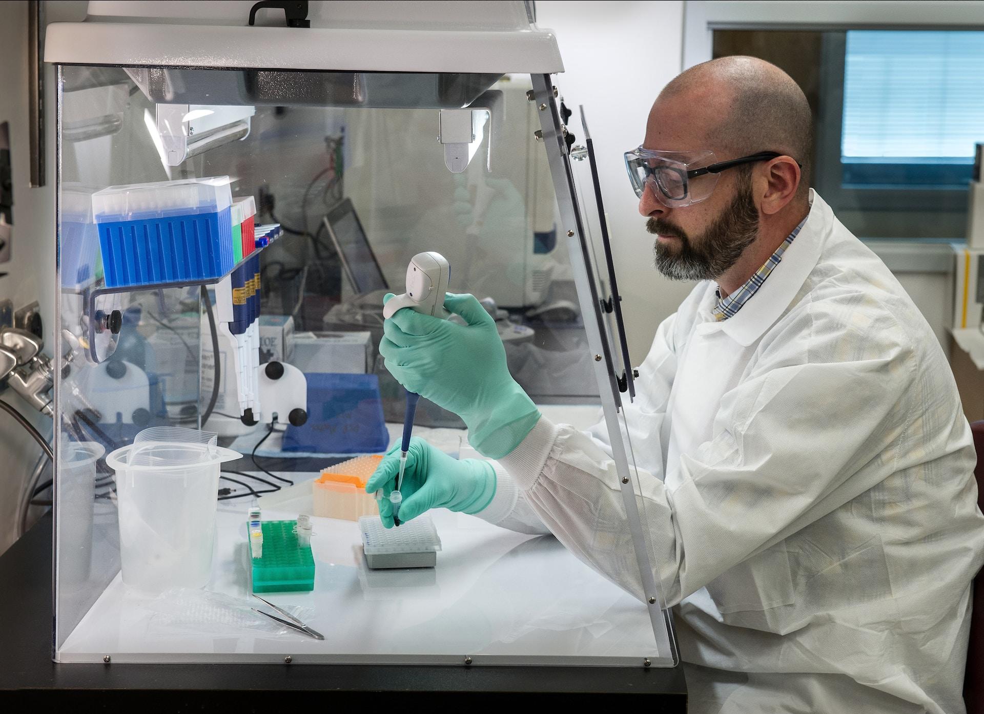 A scientist preparing samples inside a sterile environment.