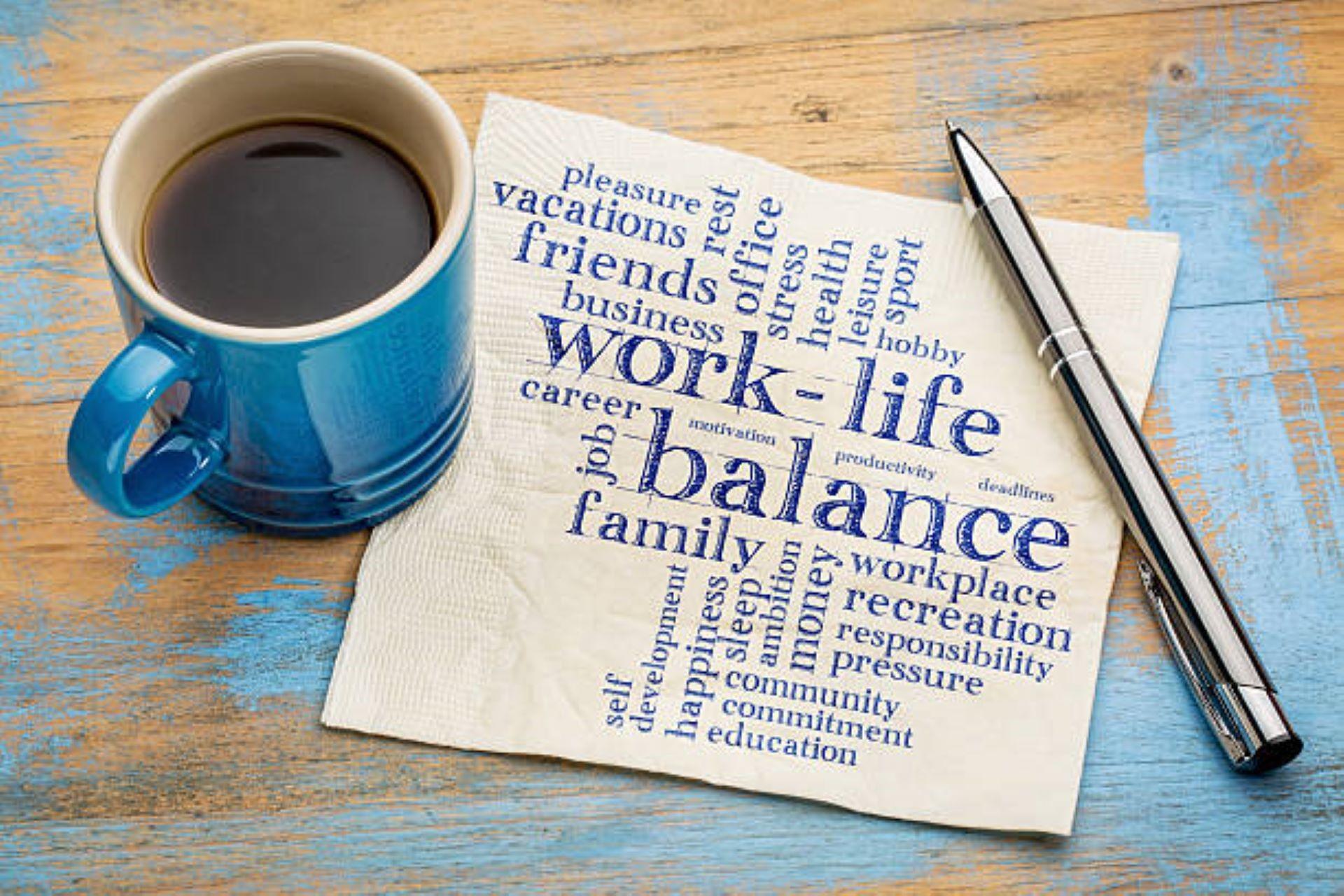 Work-life balance" written on a napkin with a pen and cup of coffee