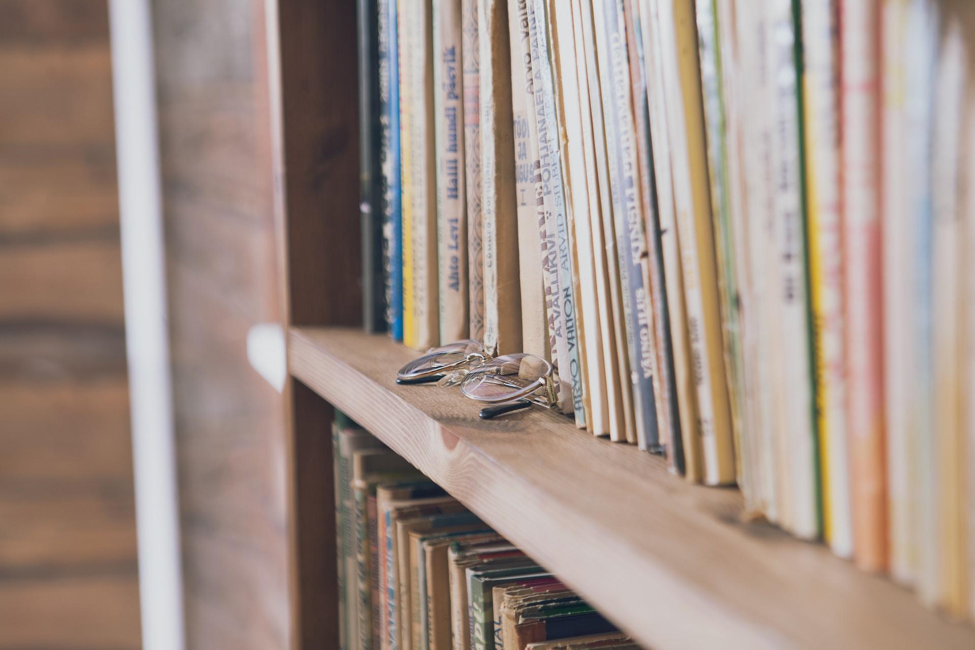 Glasses and books on a shelf.