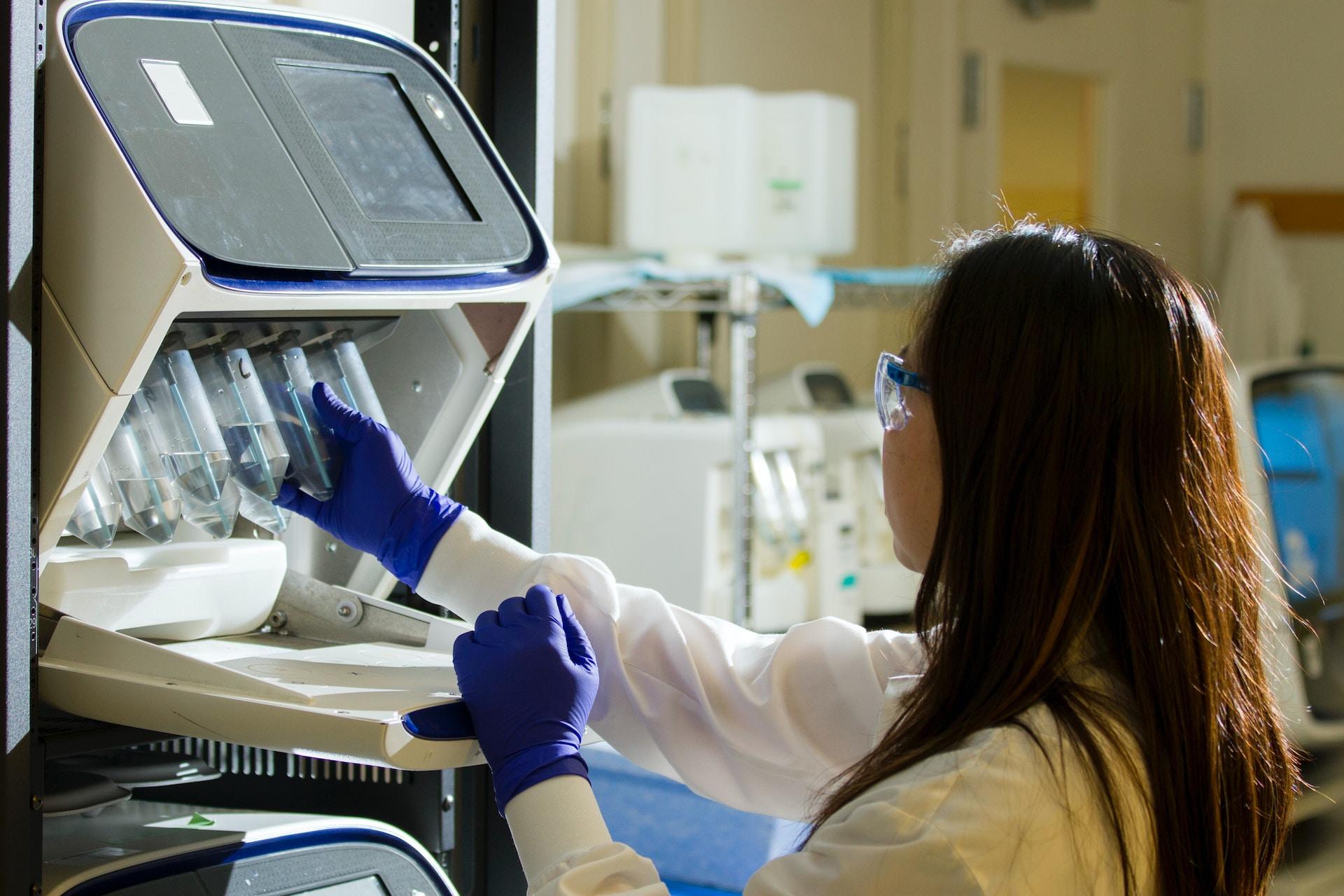 A scientist puts samples into a lab machine.