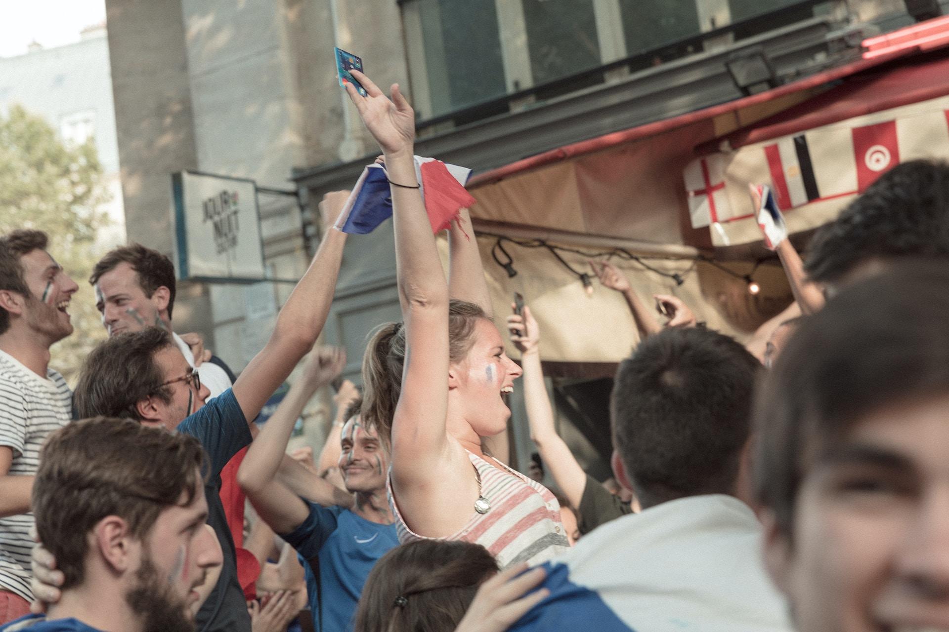 A group of protesters holding French flags and smiling.