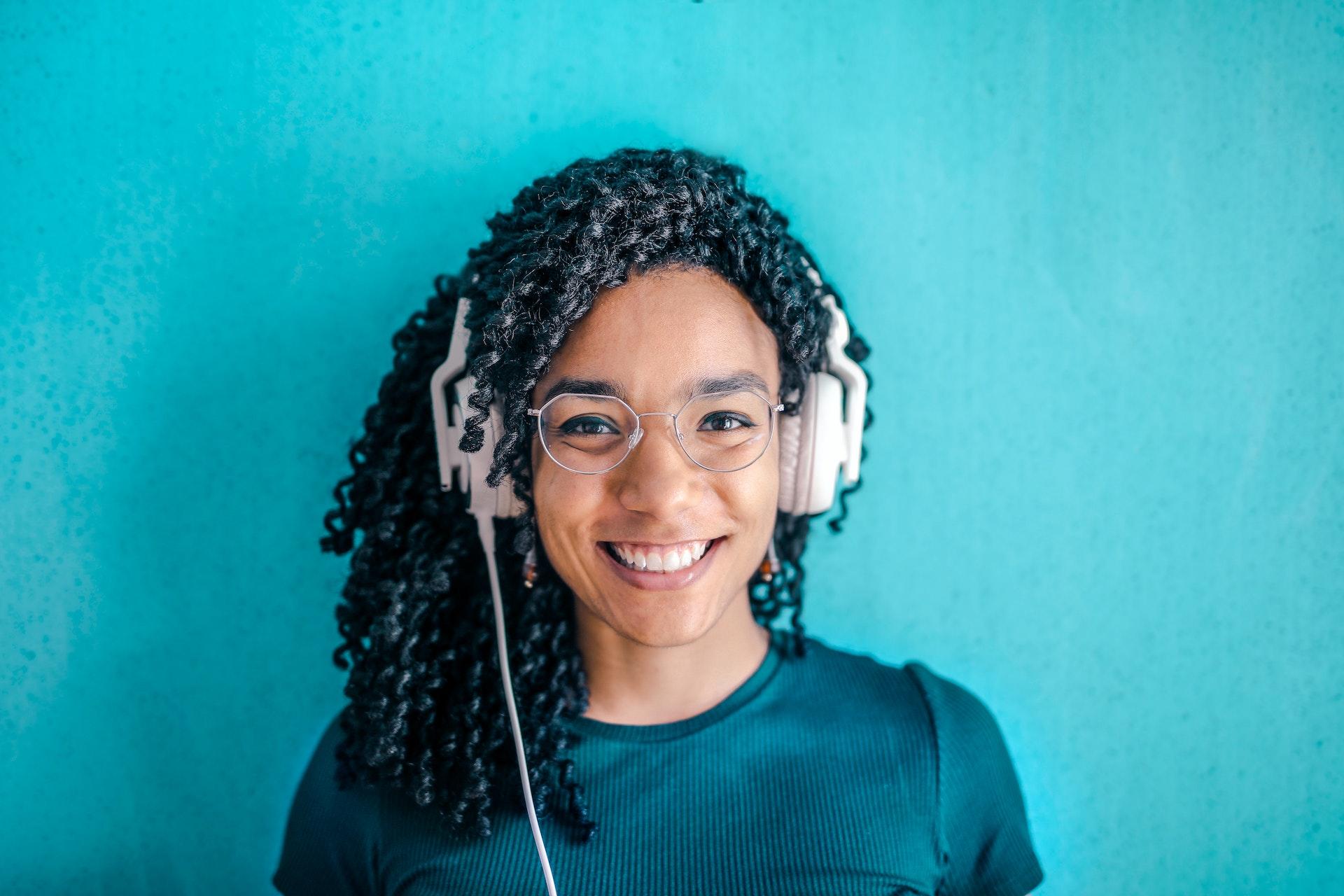 A smiling woman wearing headphones.