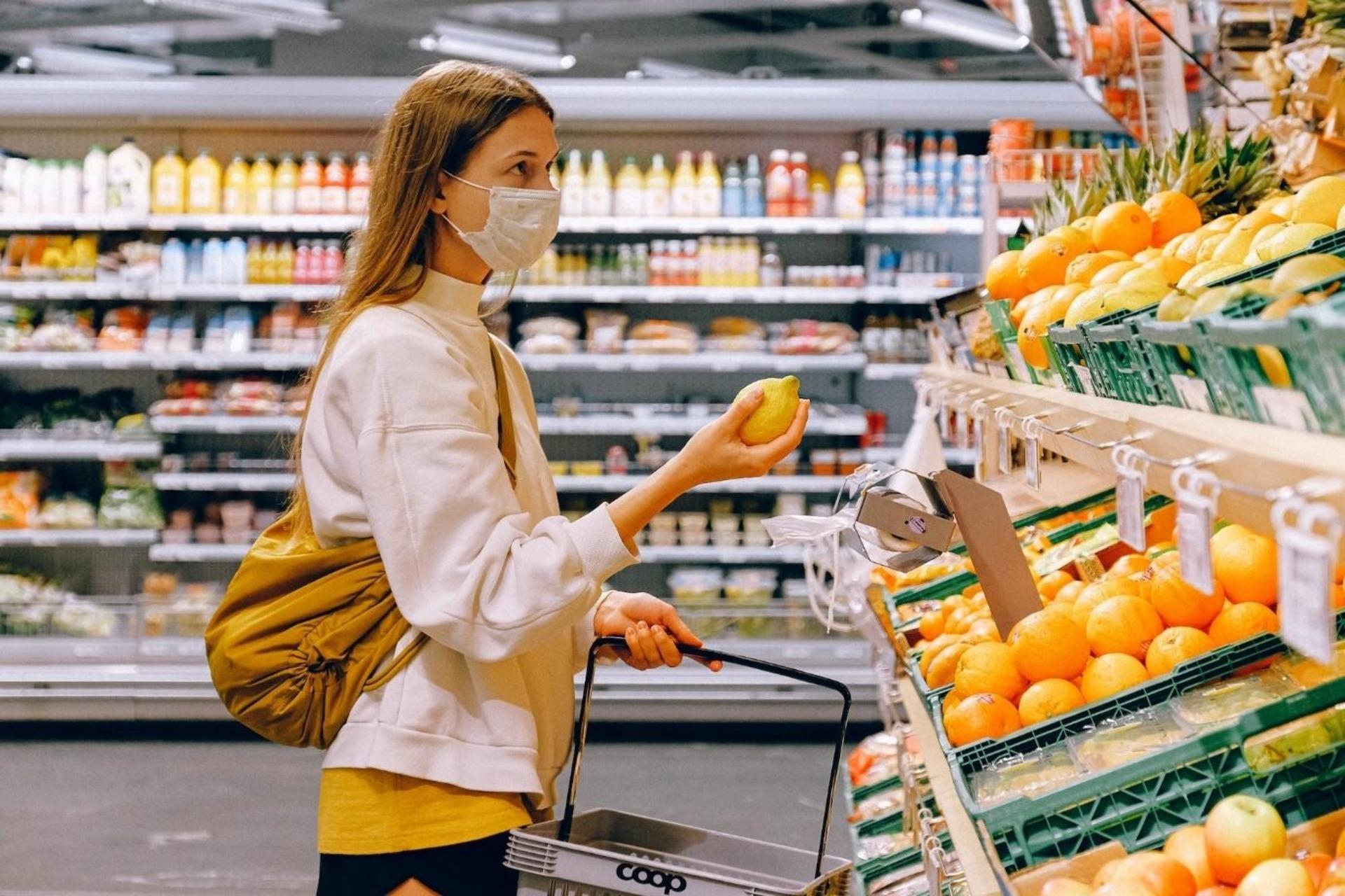 A student purchasing fruit to prepare the budget-friendly meal