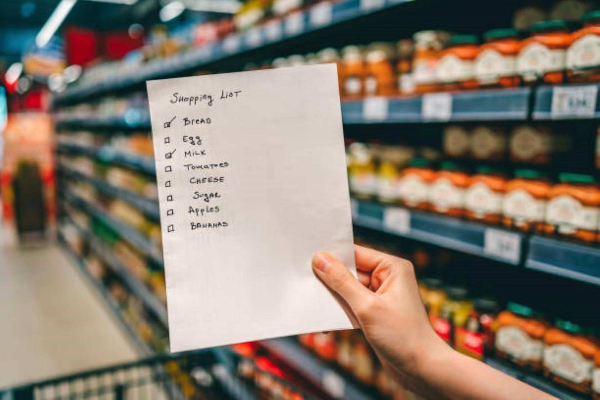 Shopping list in hand of a woman in a grocery store.