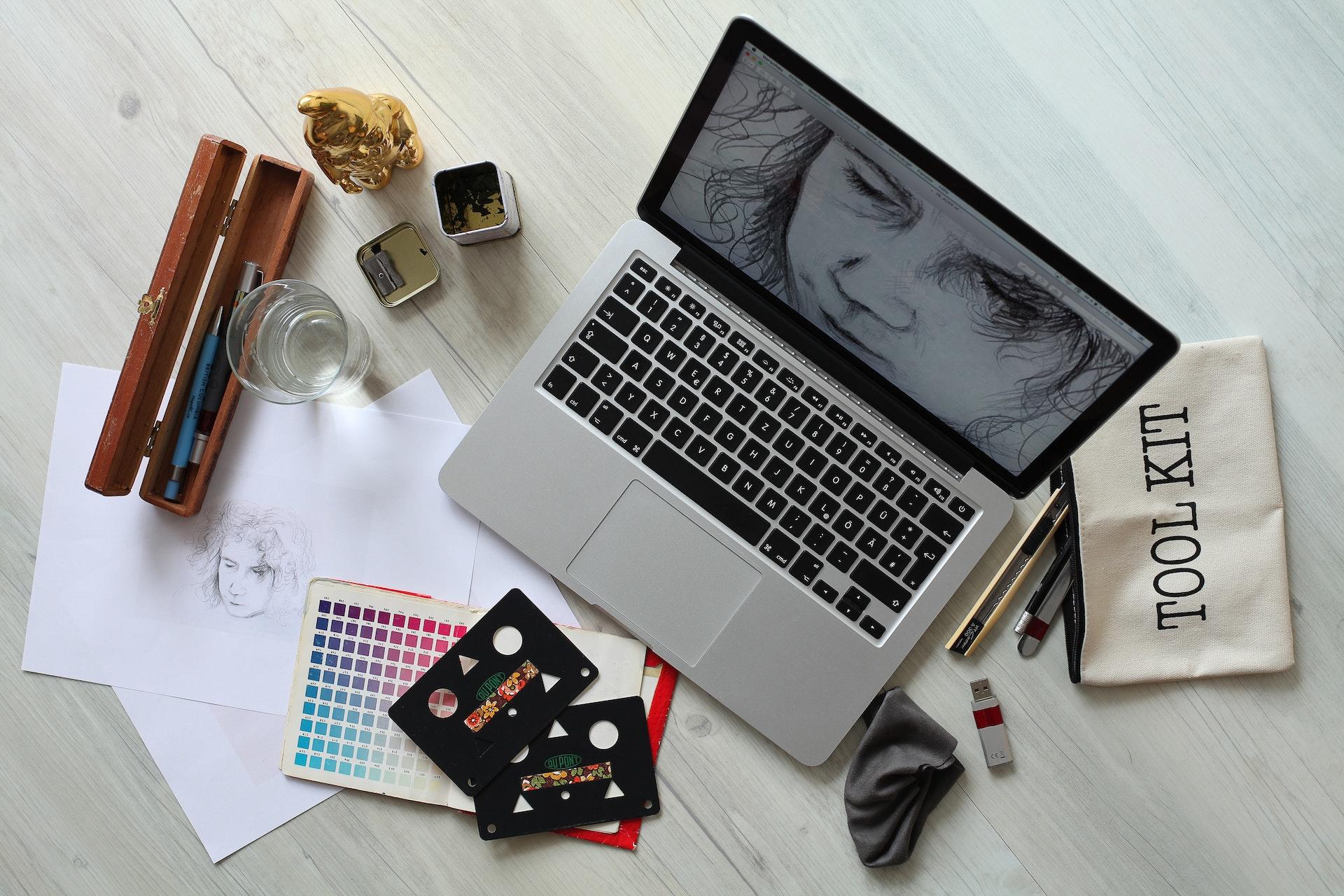 A sketchbook and a laptop show the same image as the artist learns both mediums.