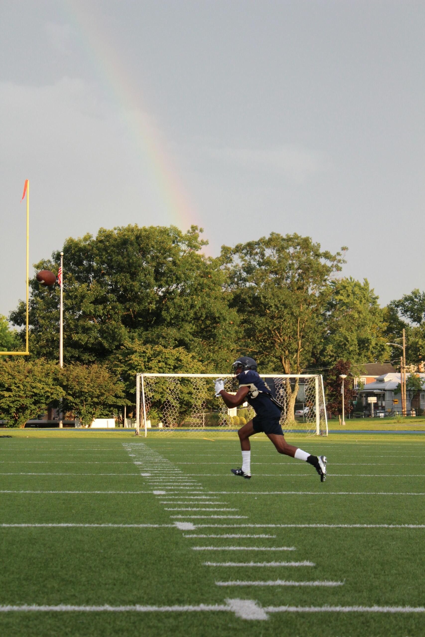 A football player in full gear running across the field with focus on their movement.