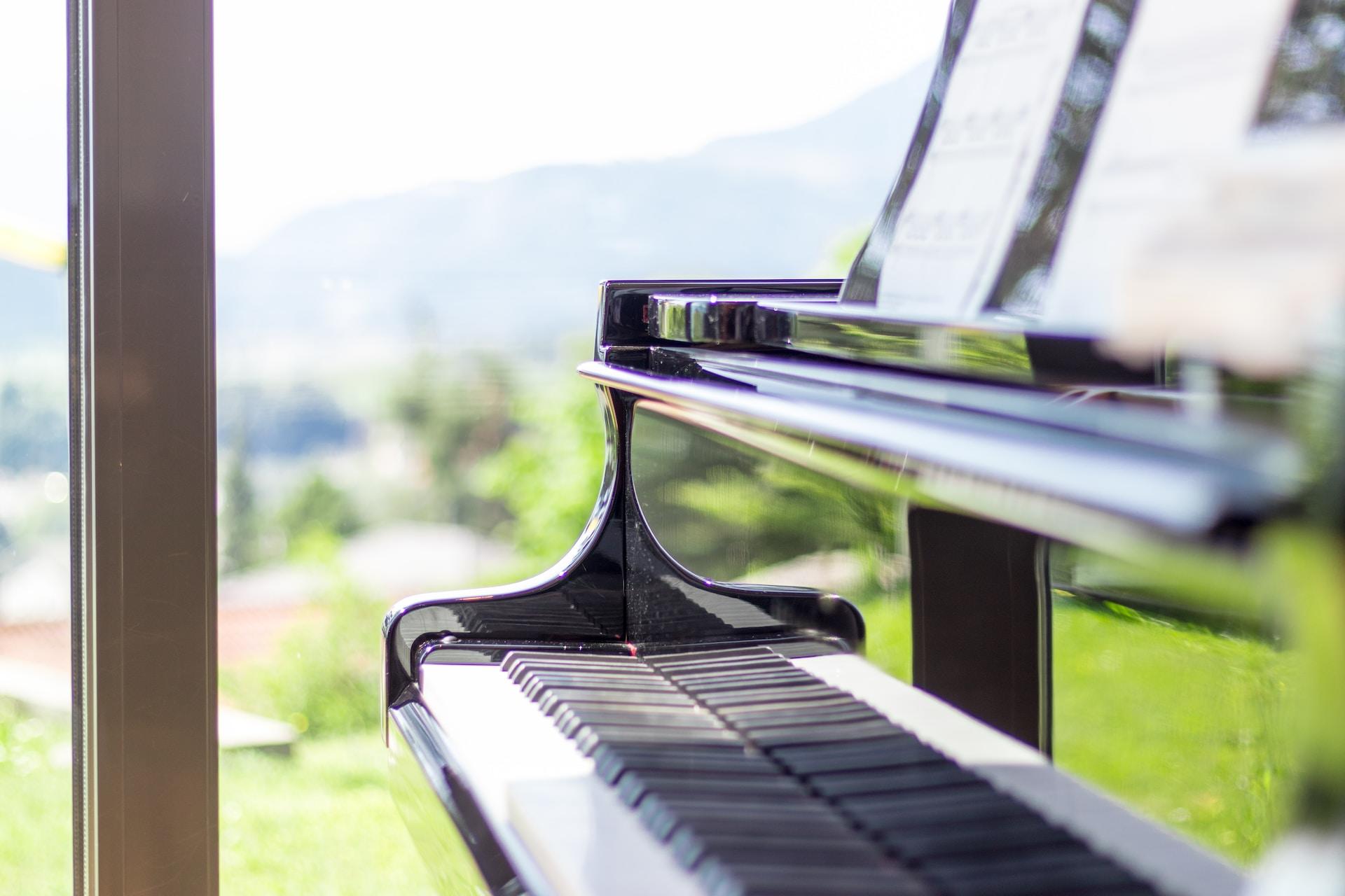 A closeup of a piano by a window.