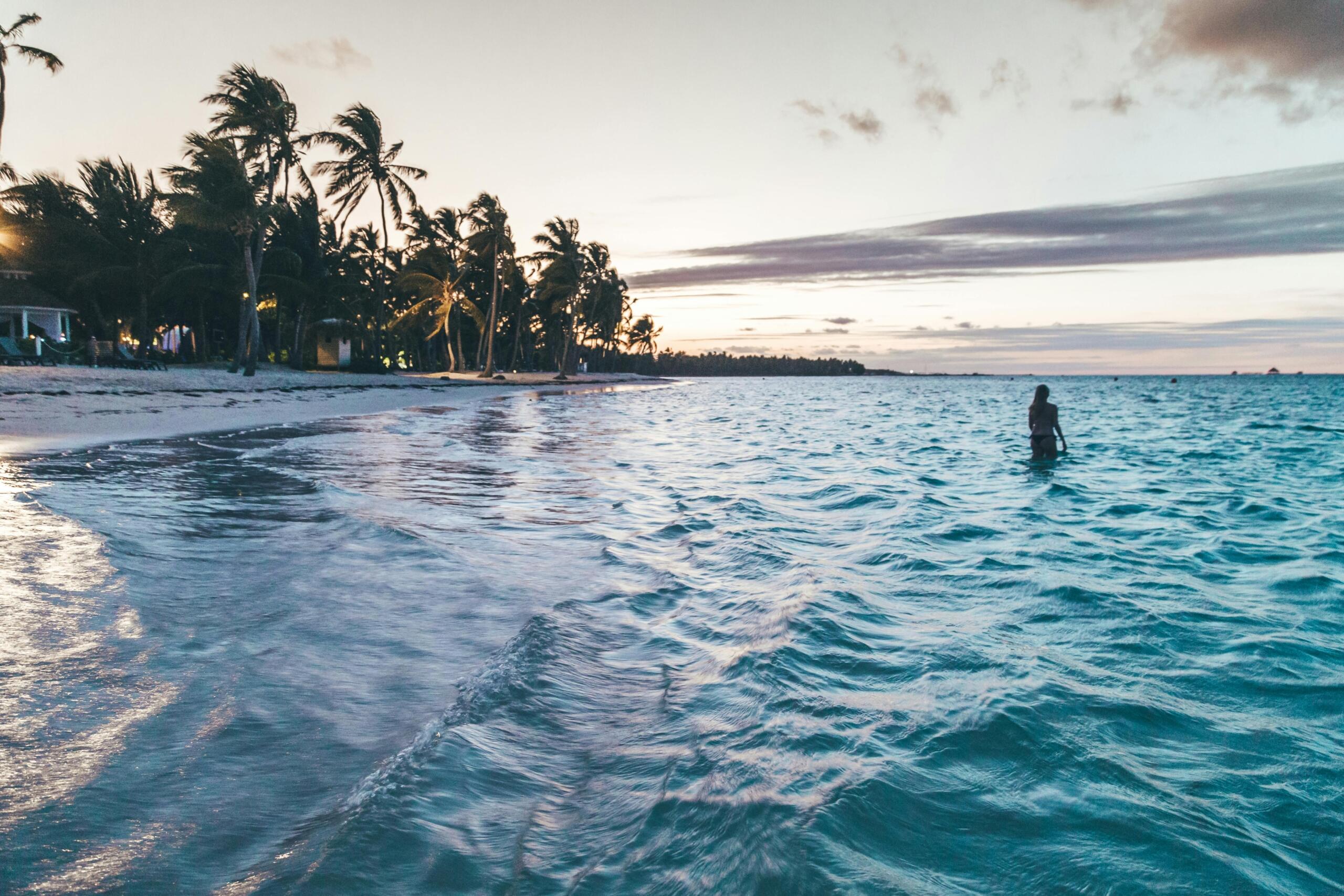 Person standing on the beach looking out at the ocean.