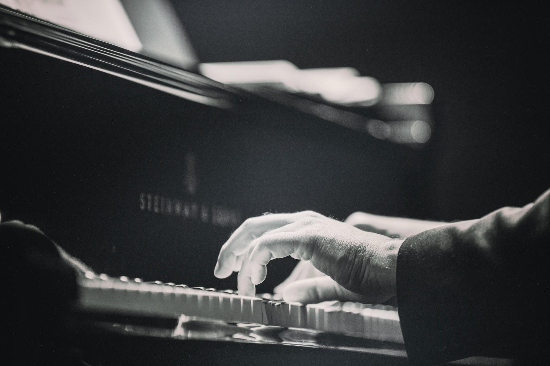 A black and white shot of a pianist playing a Steinway & Sons piano.