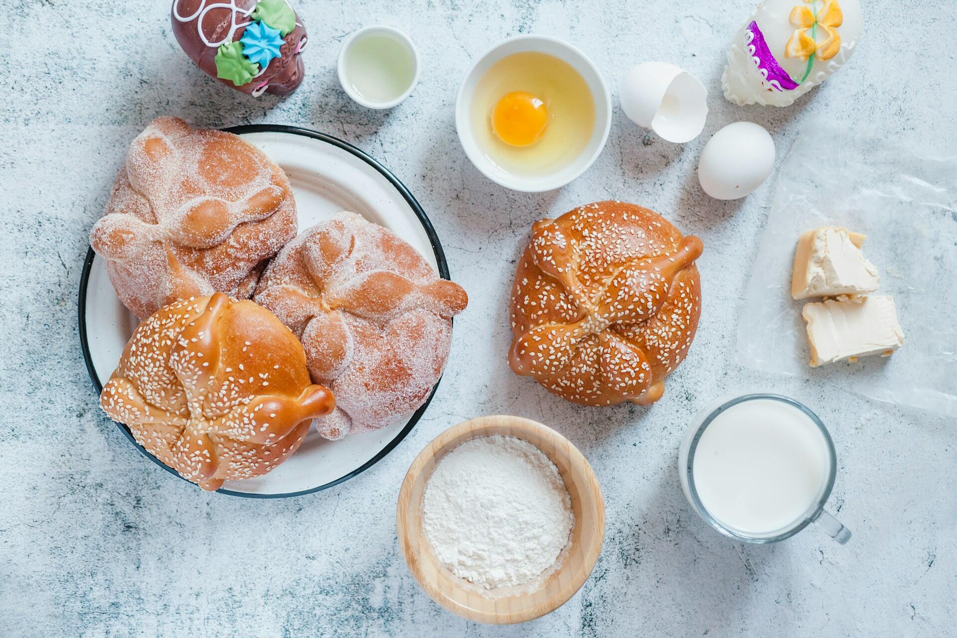 top-down view of freshly-made pan de muerto with sugar skills nearby