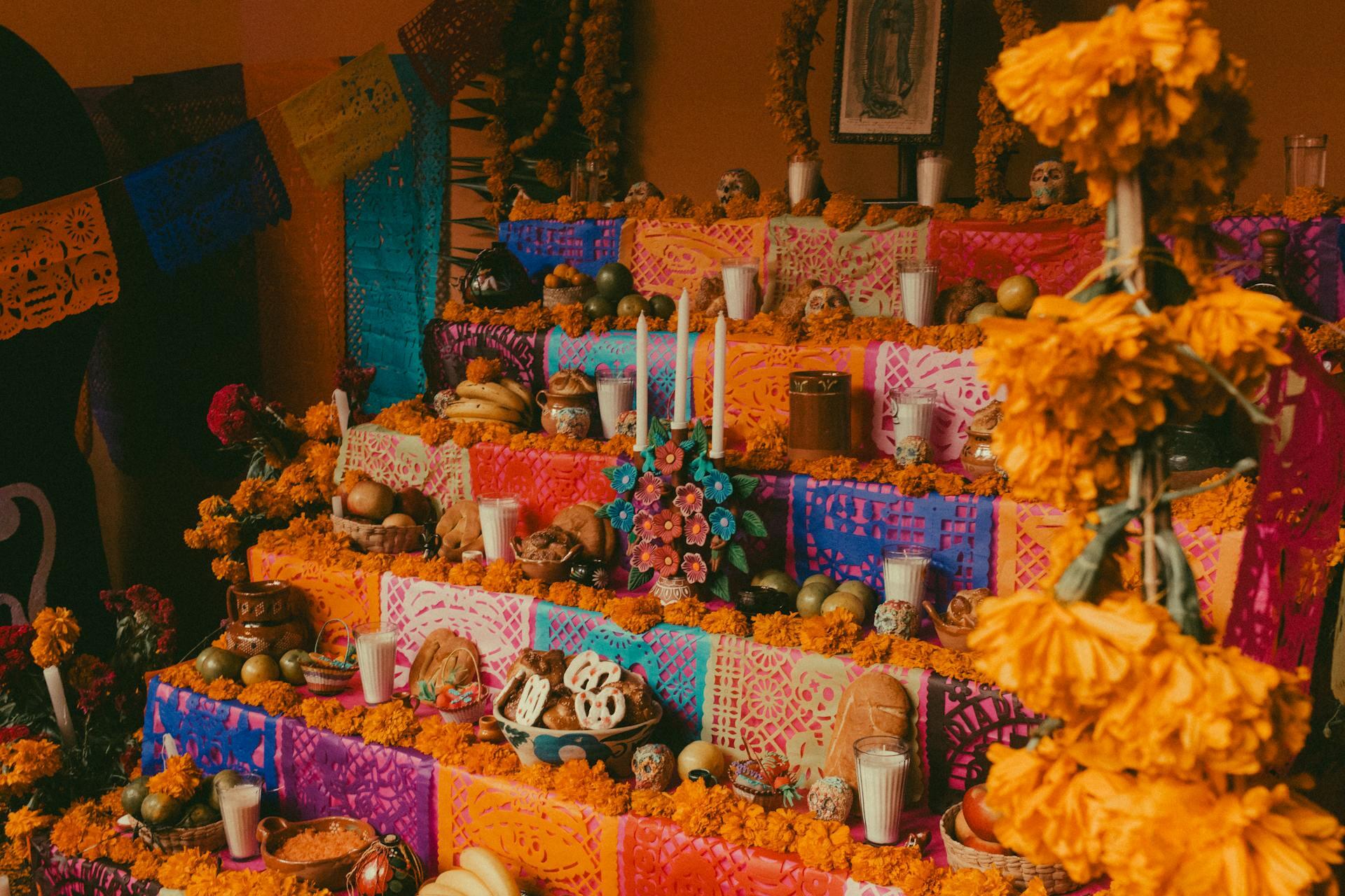 photo of colorful multi-tiered ofrenda with flowers and food