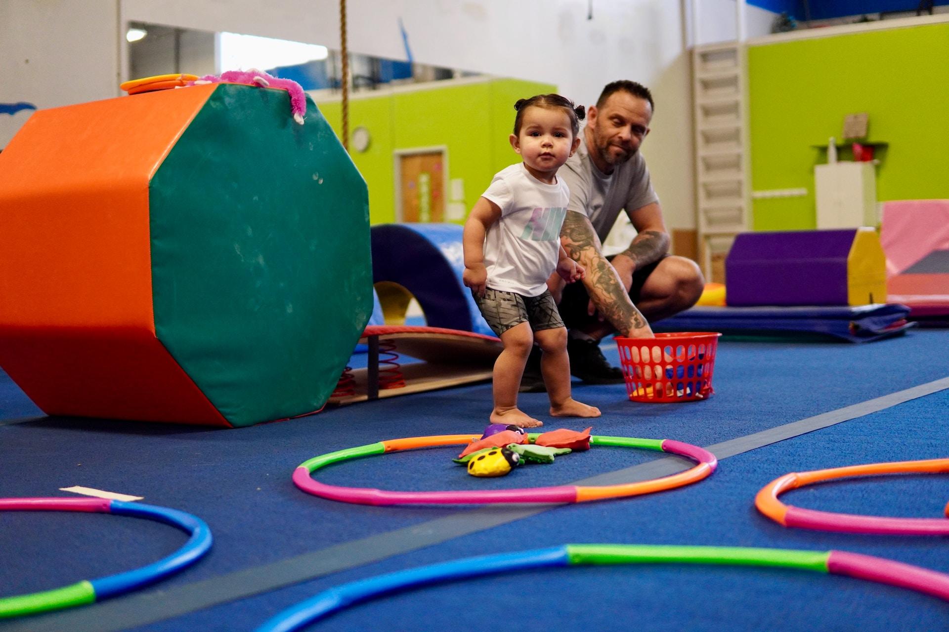 A toddler enjoying an introductory gymnastics class.