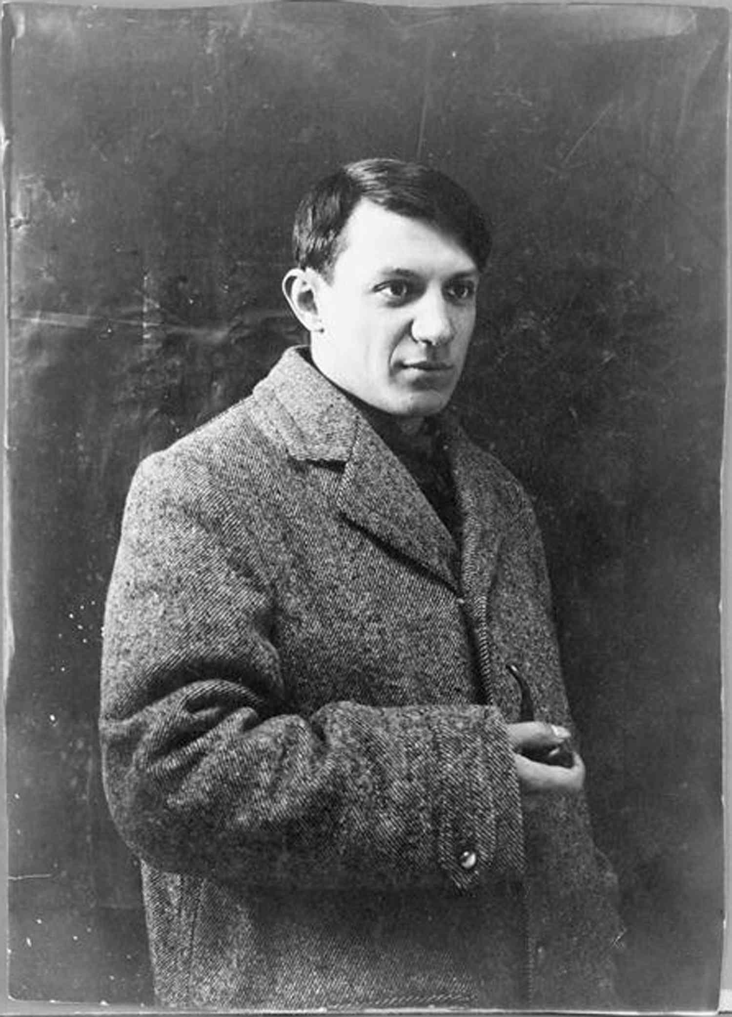 Black-and-white portrait of Pablo Picasso with a coat.