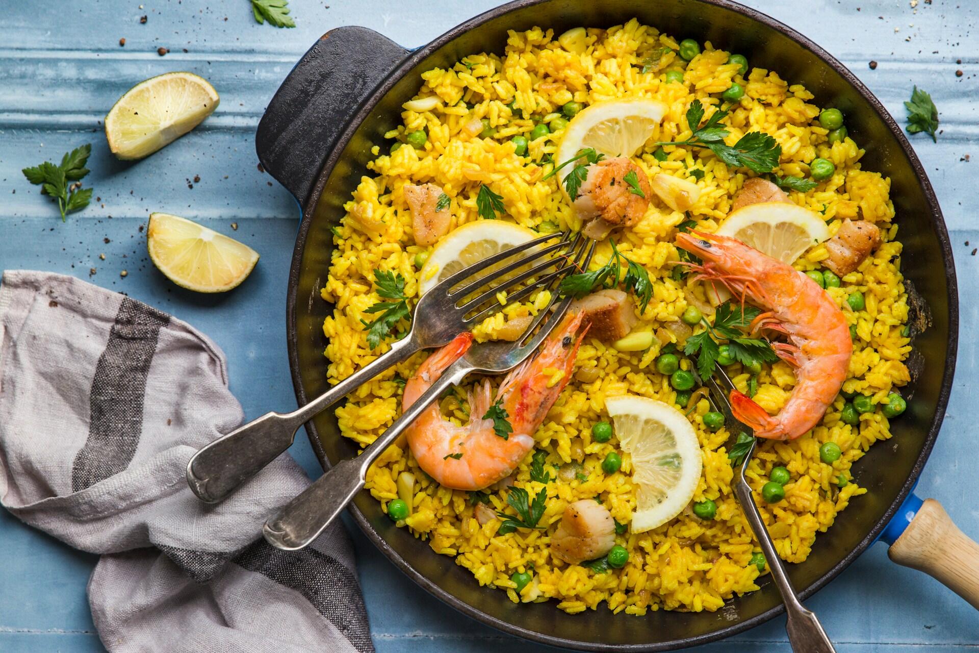 Paella with lemon, shrimp, and peas.