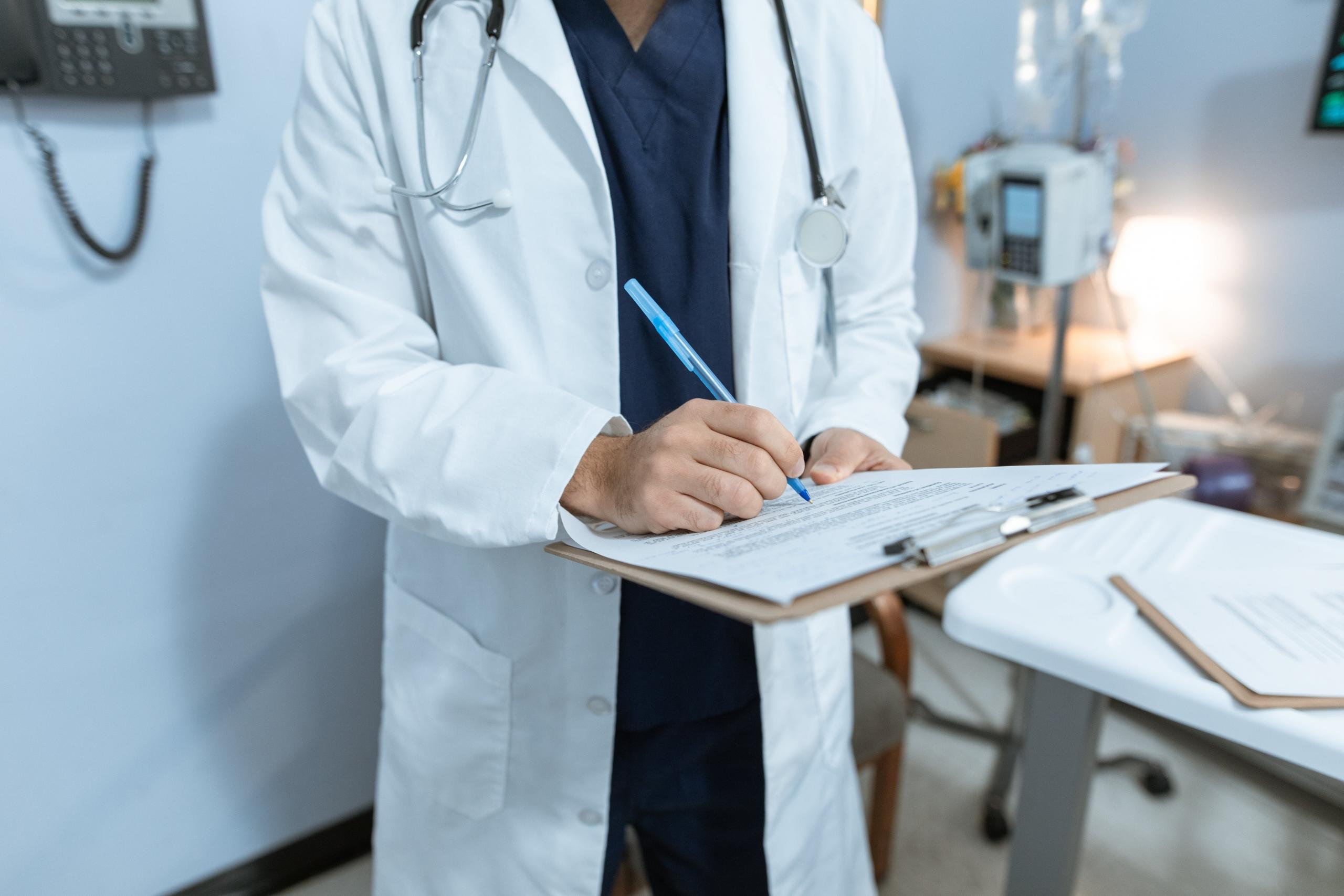 A nurse taking notes on their clipboard.