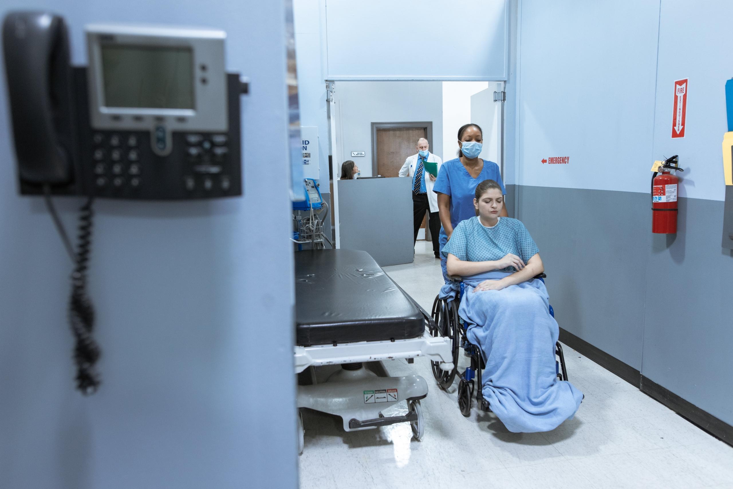 A nurse wheeling a patient around the hospital.