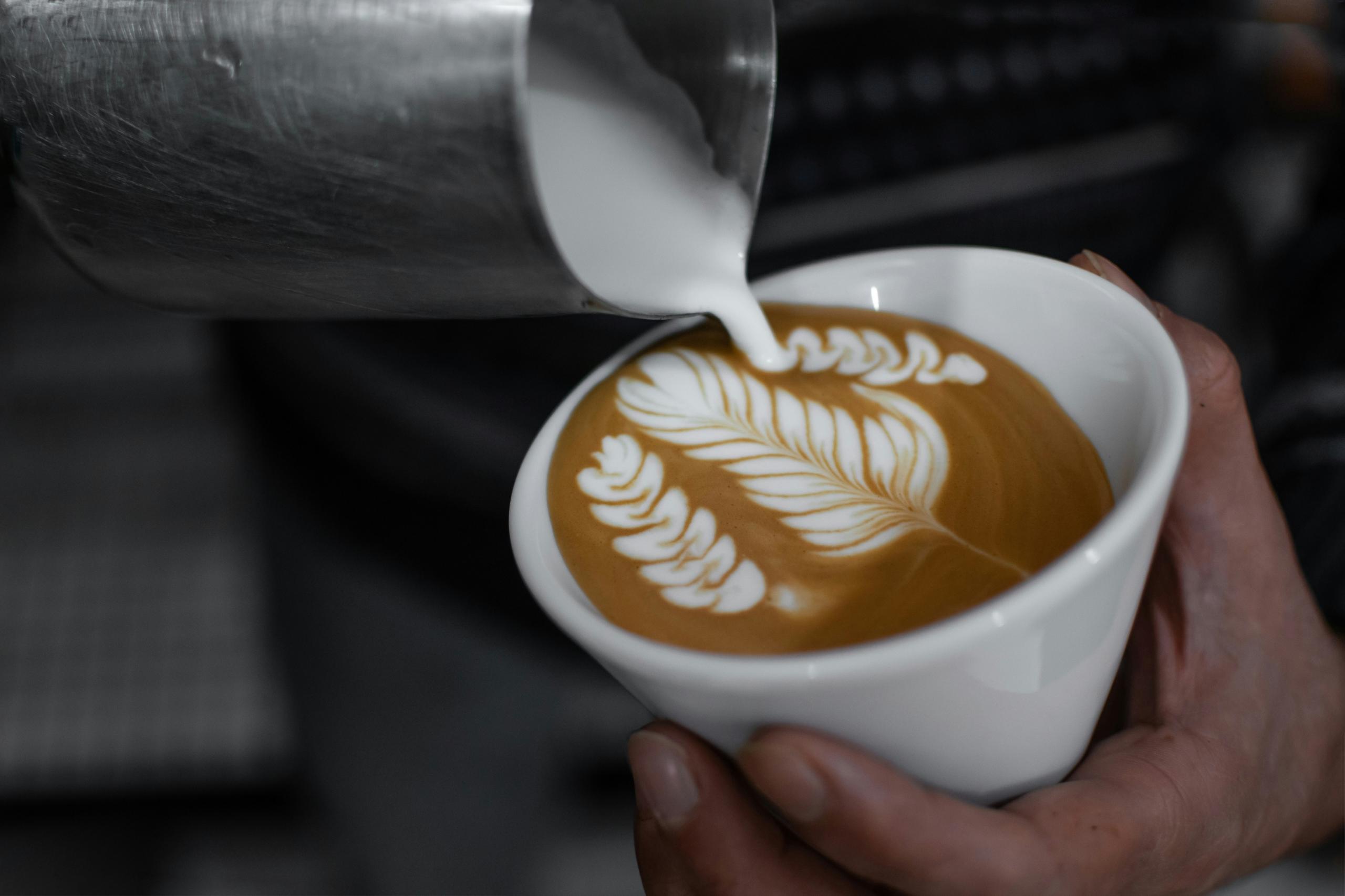 A barista completing their latte art.