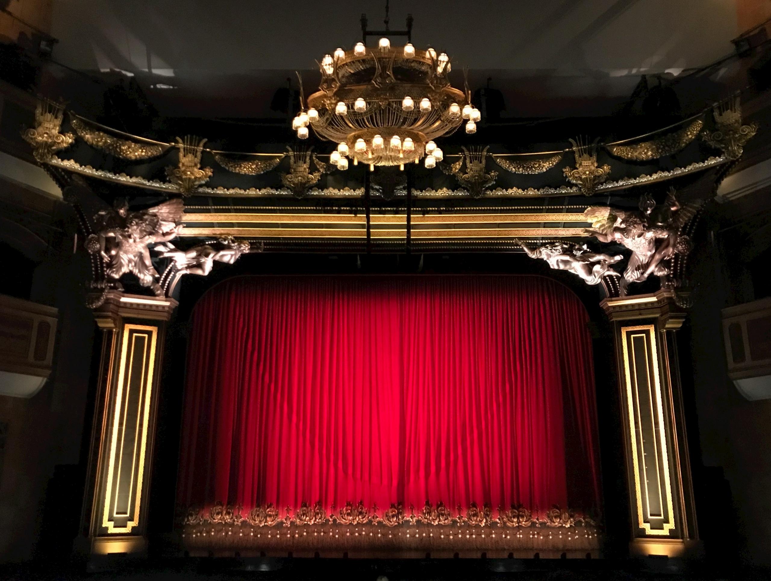 A theater with a red curtain.