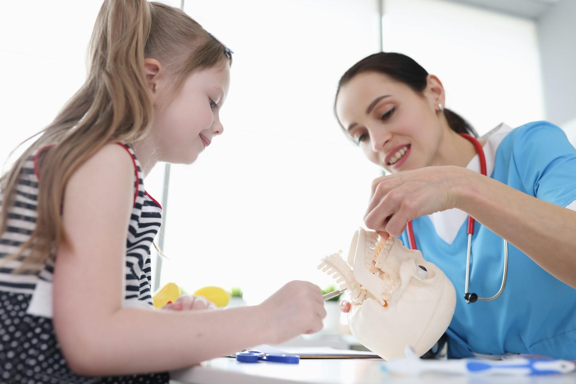 A tutor educating a child with an educational skull.