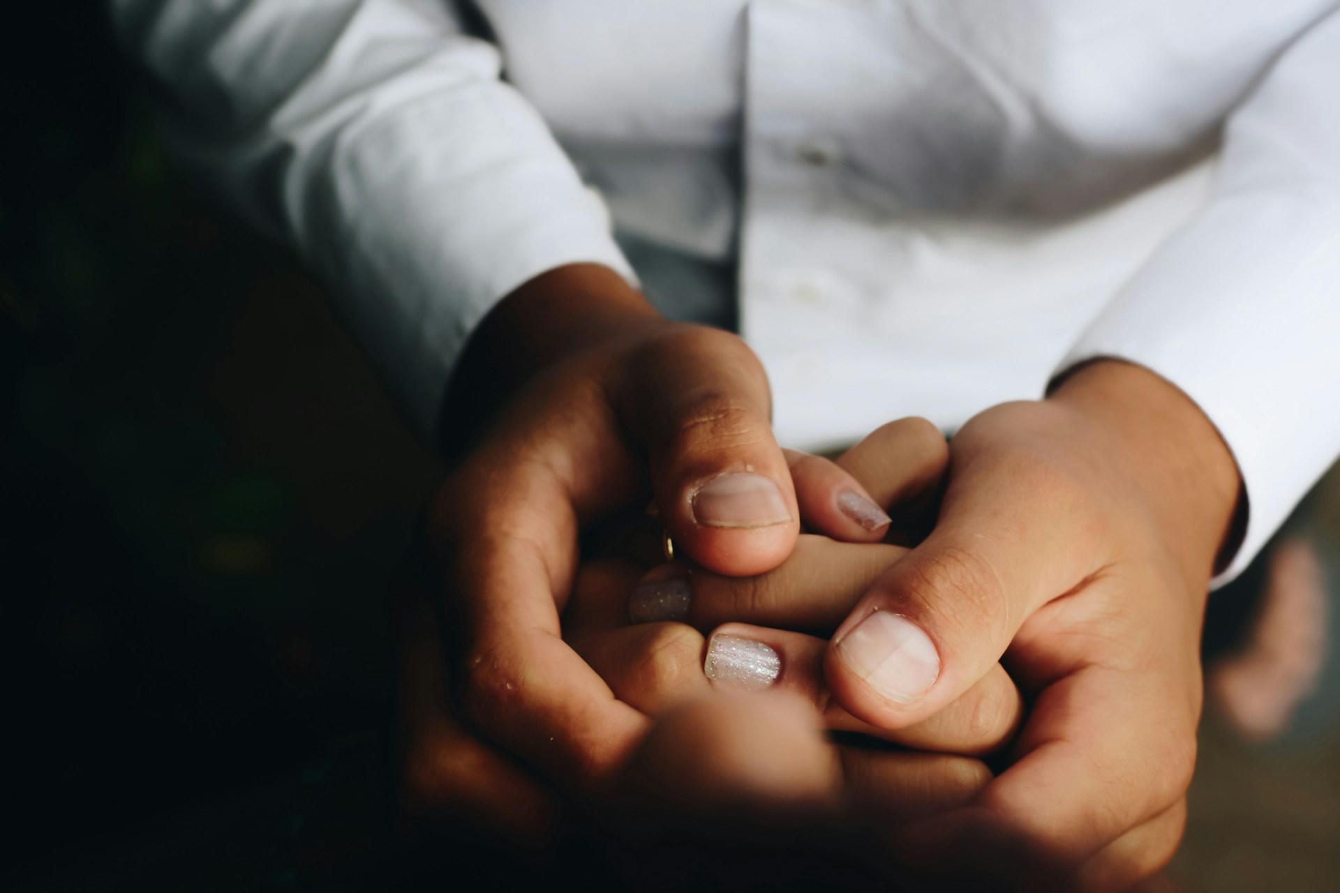 Nursing holding a patient's hand.