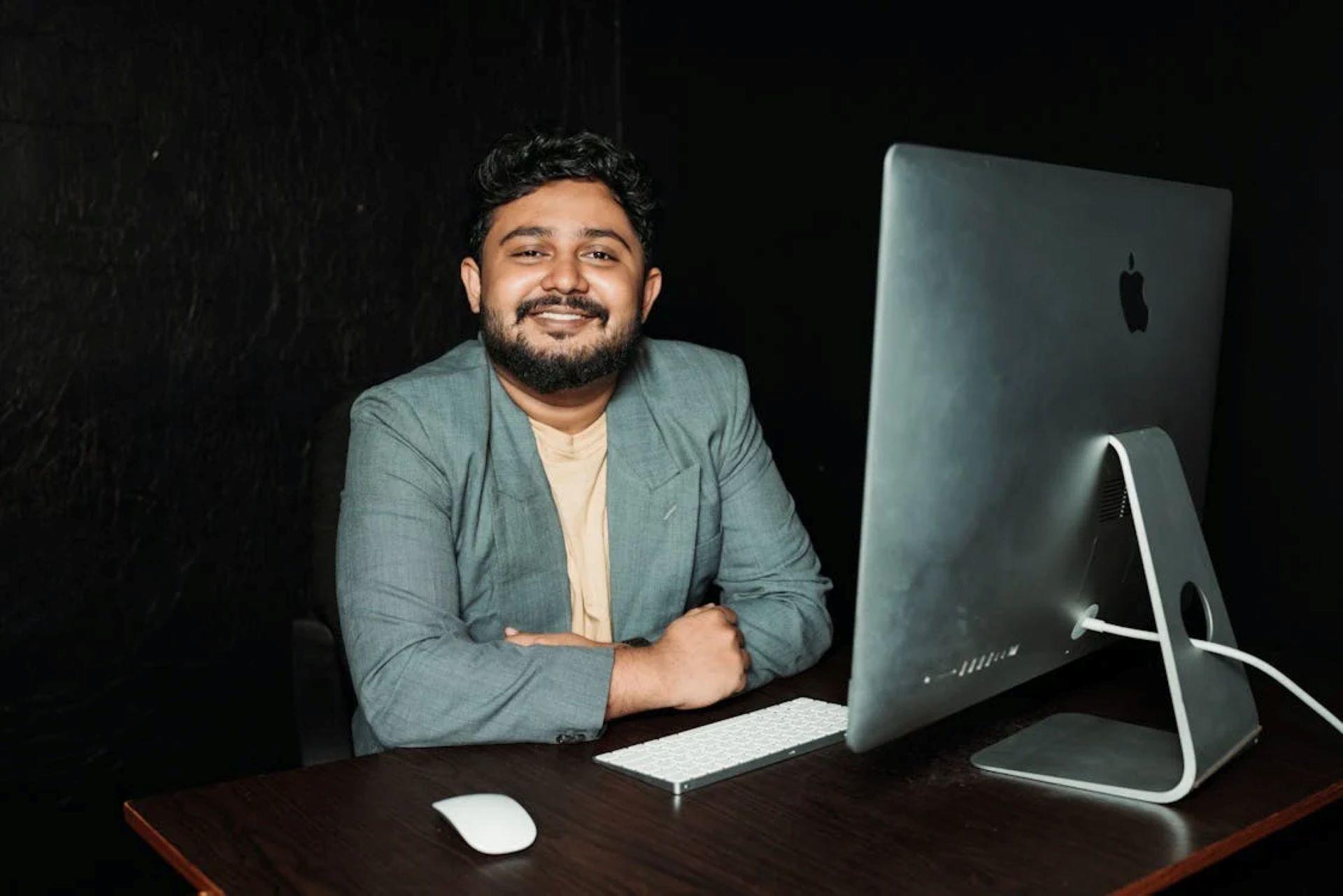 A person working on a computer at a desk in an office setting.