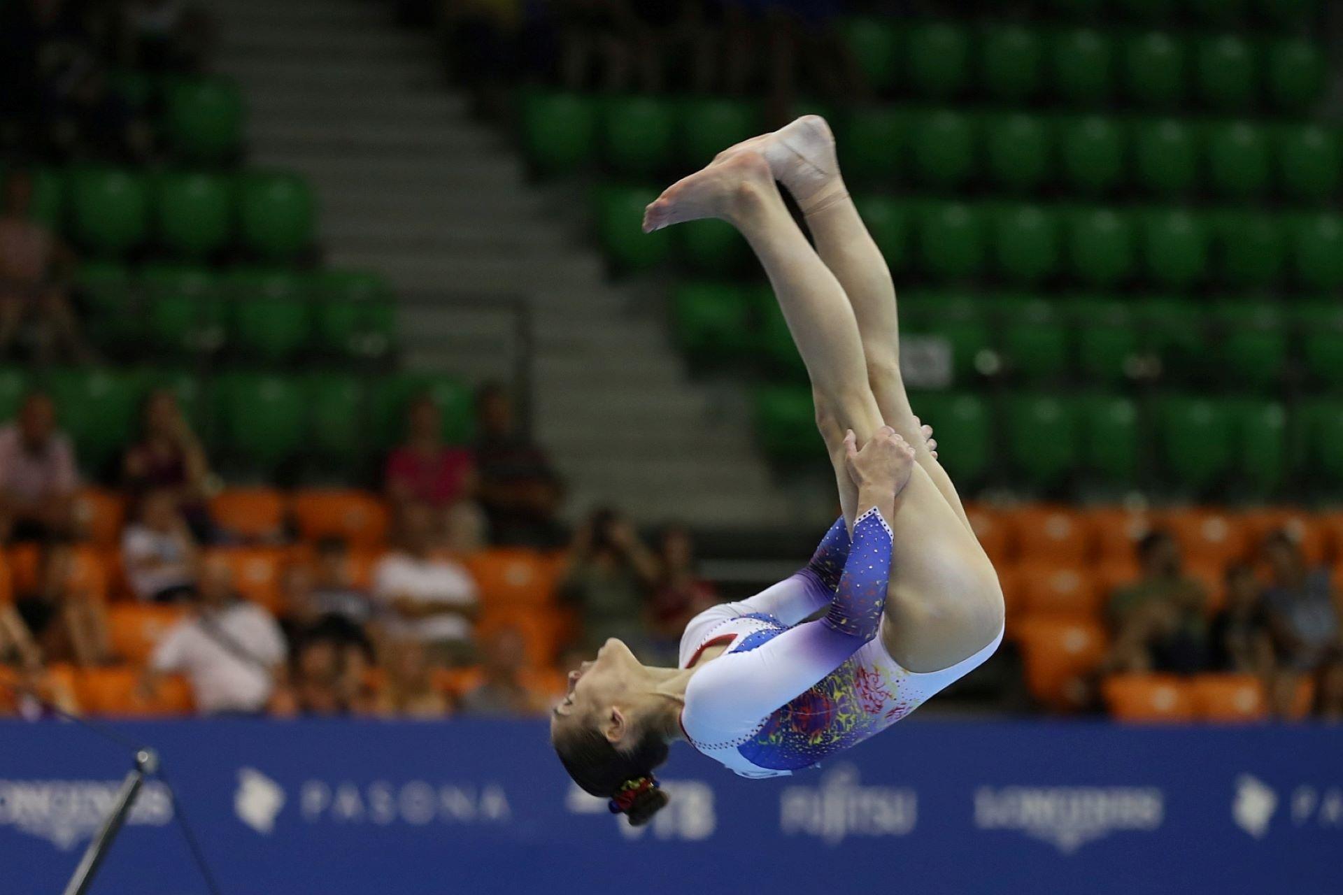 A gymnast mid-air during a floor routine.