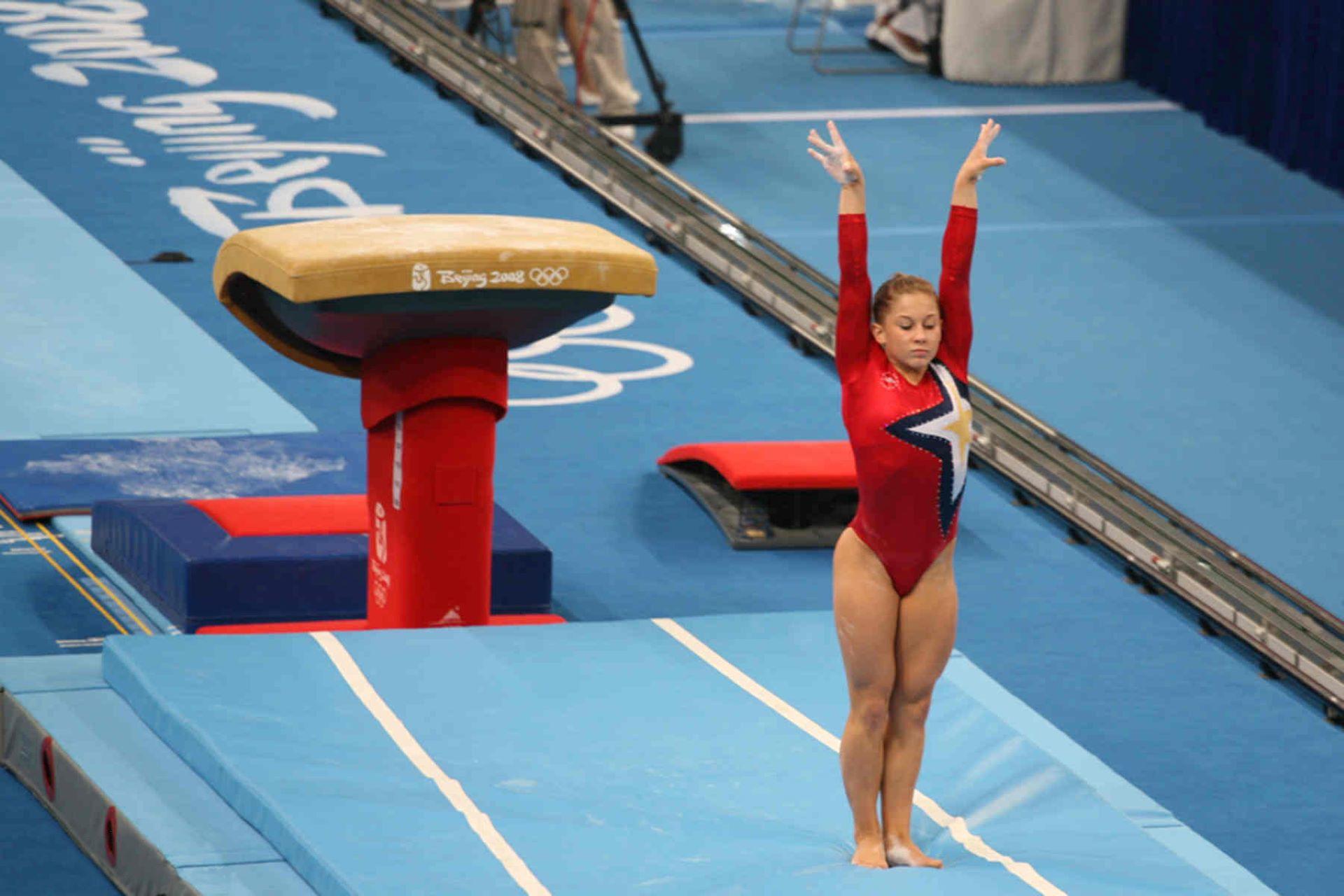 A gymnast at the end of a vault.