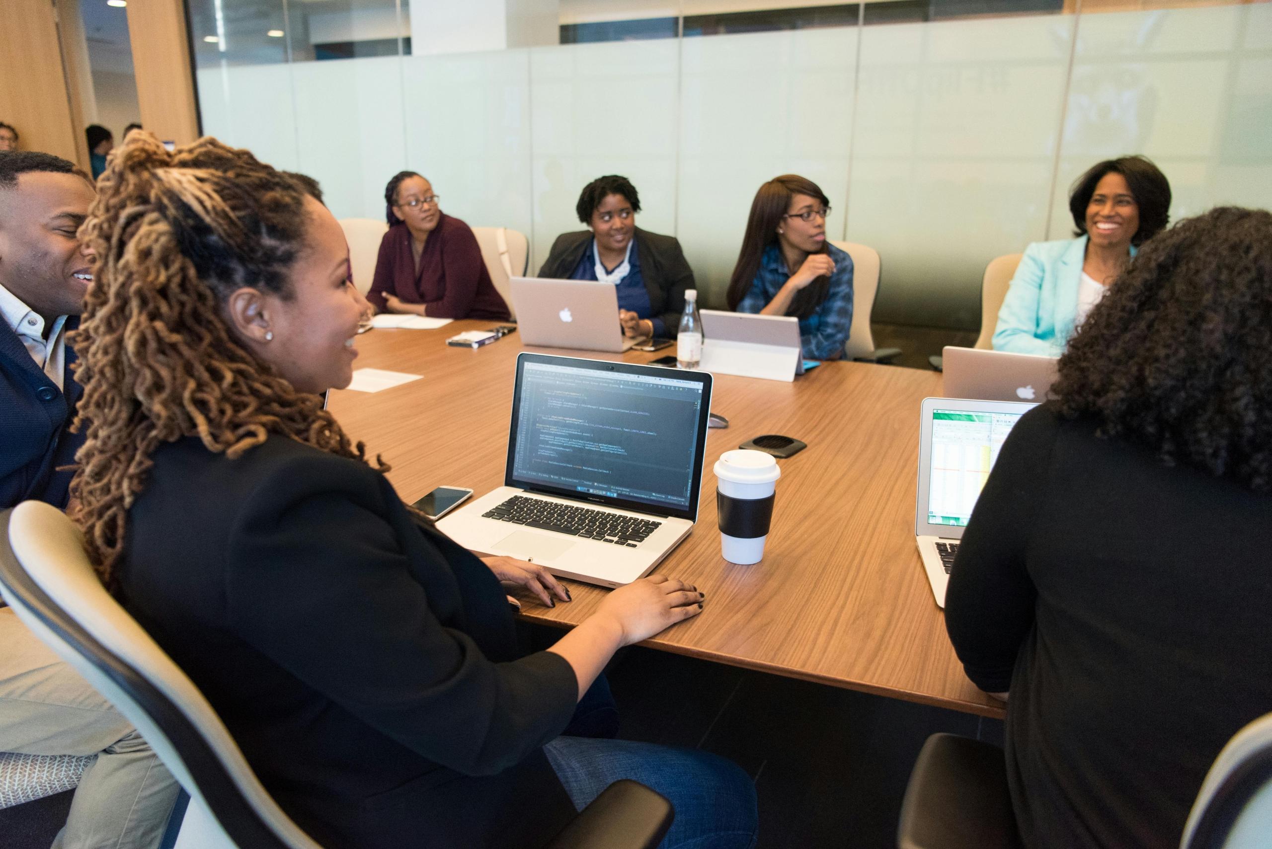 A group of people discussing on their laptops