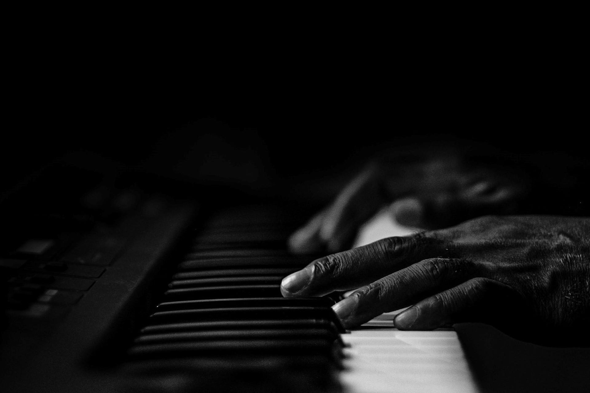 A closeup of hands on a piano keyboard.