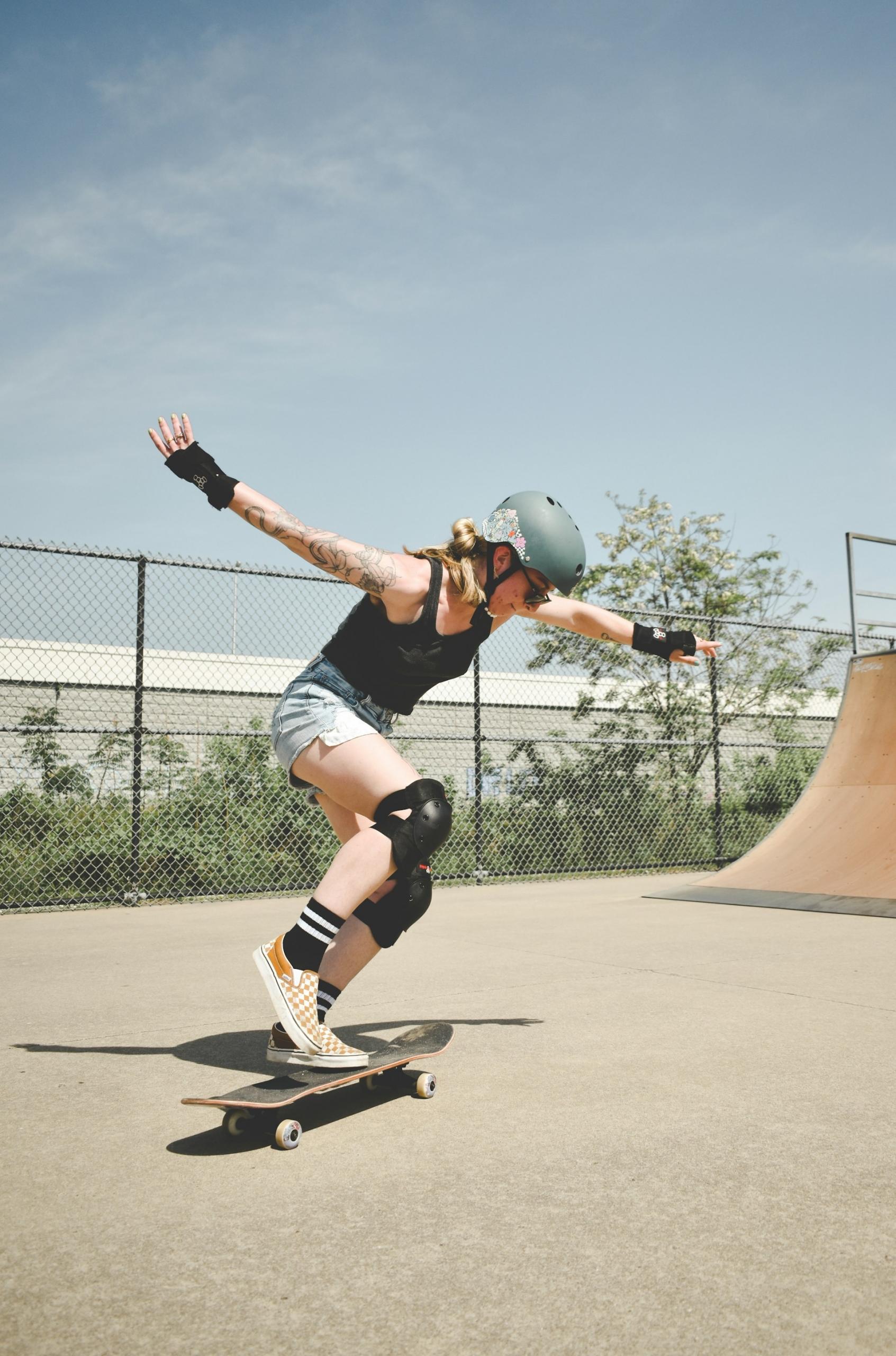 A skater wearing a helmet, wrist guards, and knee pads, while doing a trick