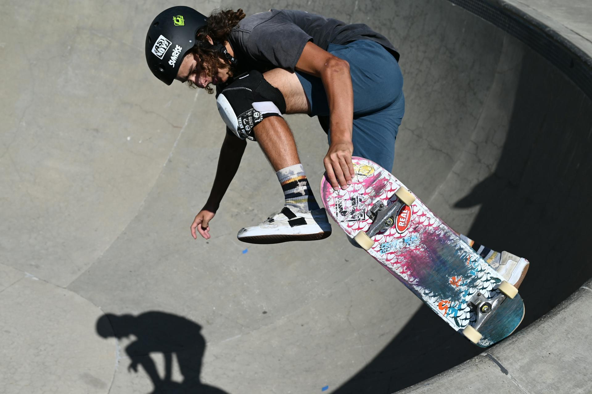 A skateboarder wearing protective gear and skating in a half pipe