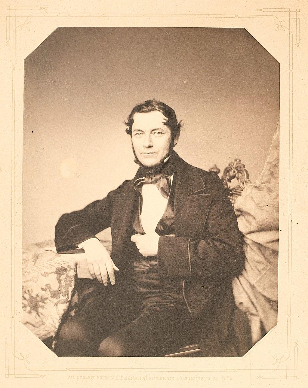 A portrait of Robert Bunsen on orange paper.